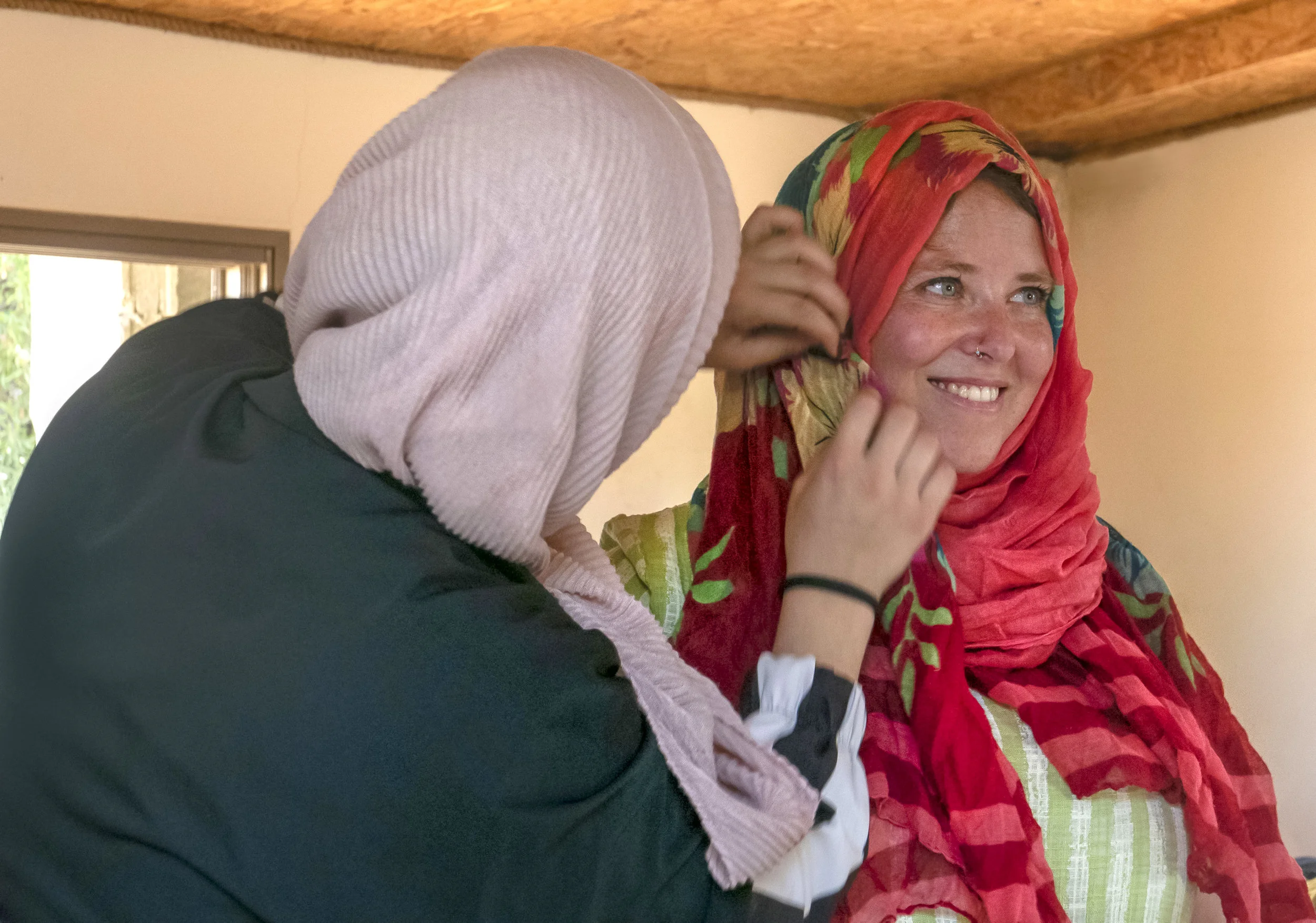 A Palestinian participant wraps an Israeli participant’s headscarf in the hijab manner, all with light humour and good faith