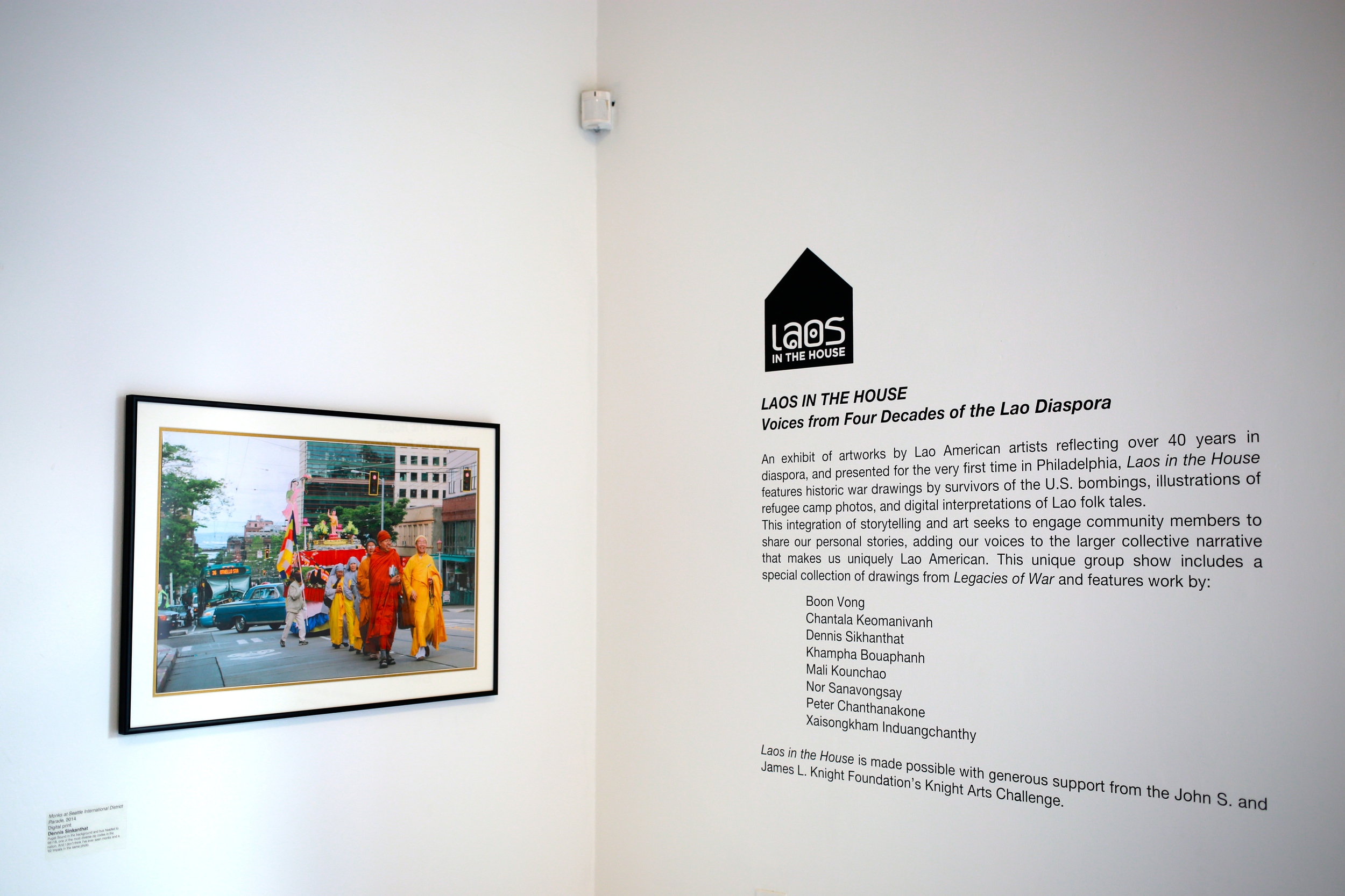 "Monks at Seattle International District Parade, 2014" by Dennis Sinkanthat and title gallery wall narrative