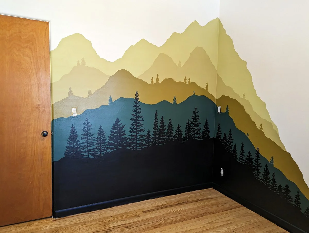 Mountain Bedroom mural painted in michigan with mountain layers and pine trees in green and gold.
