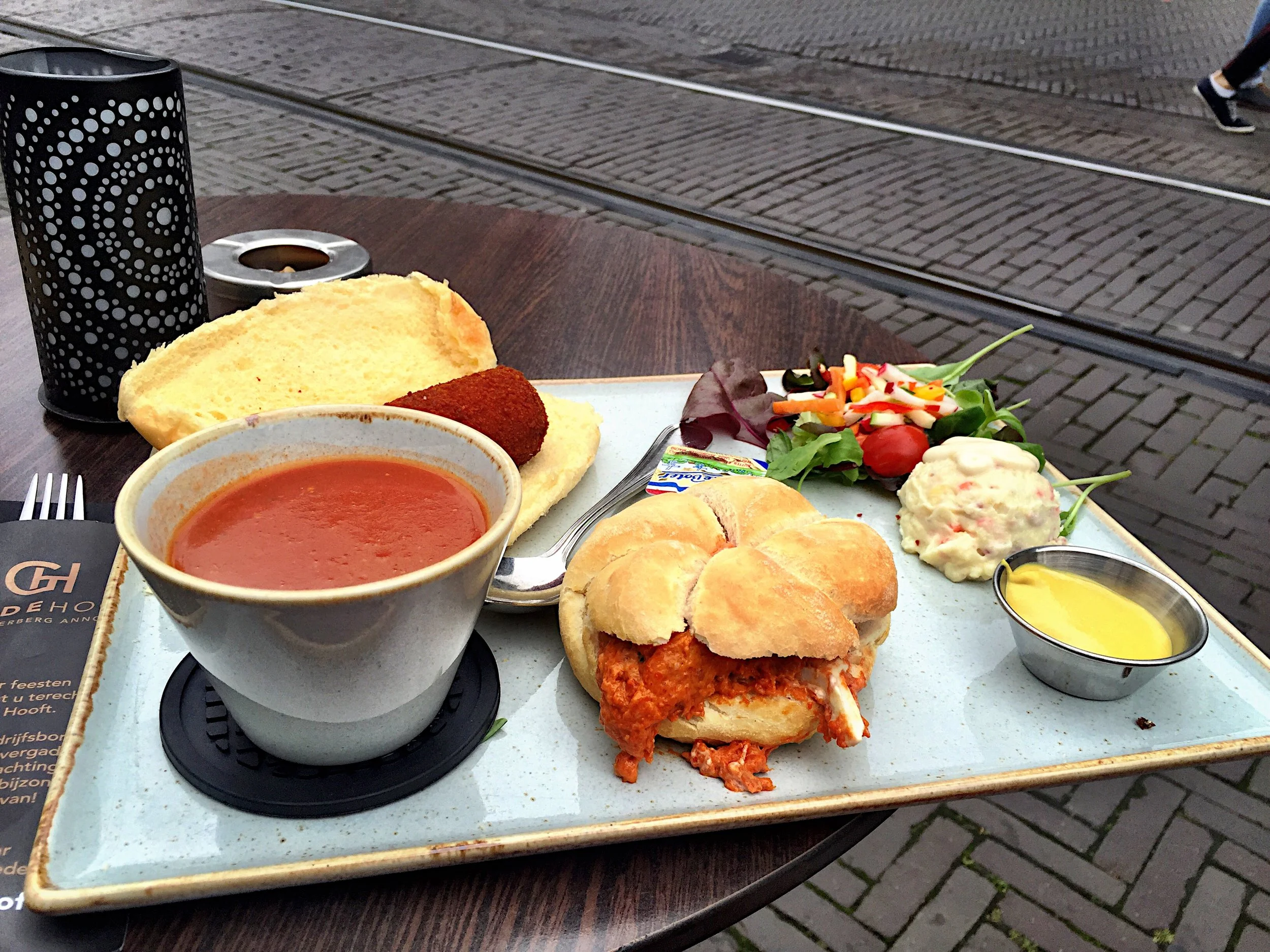 A "typical Dutch meal": some weird soup, a weird meat goo on a roll, a fried thing on a roll, a glob of mayo and potato, a few leaves of lettuce and mustard mayo for some unknown reason
