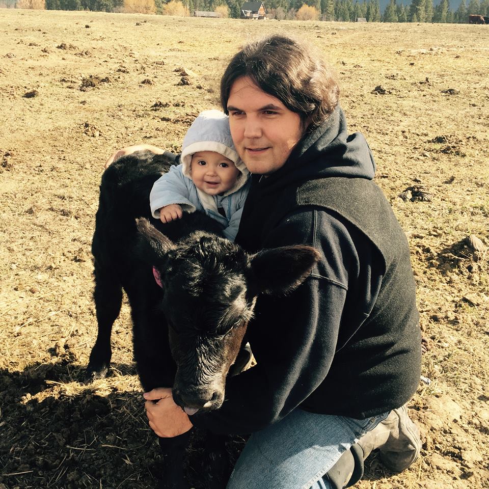 Kale Thomas with his son and a calf