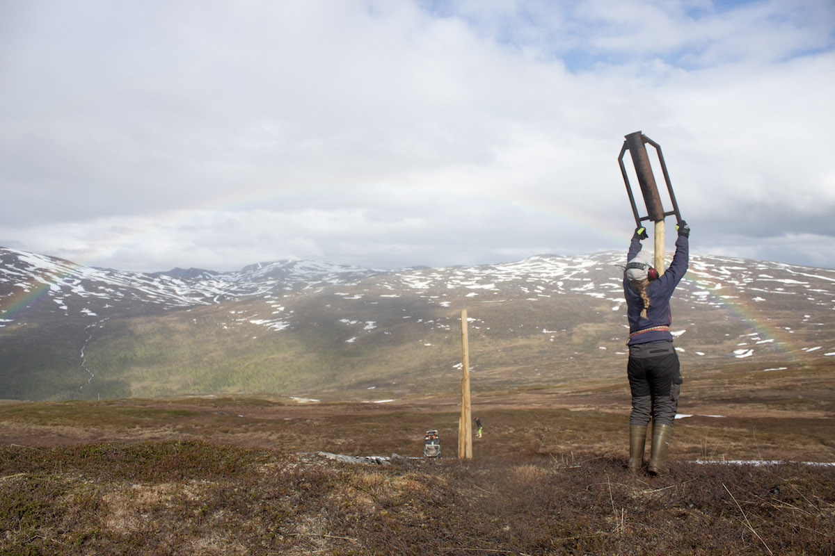 Sara Katrine Aleksandersen pounds a fence post.
