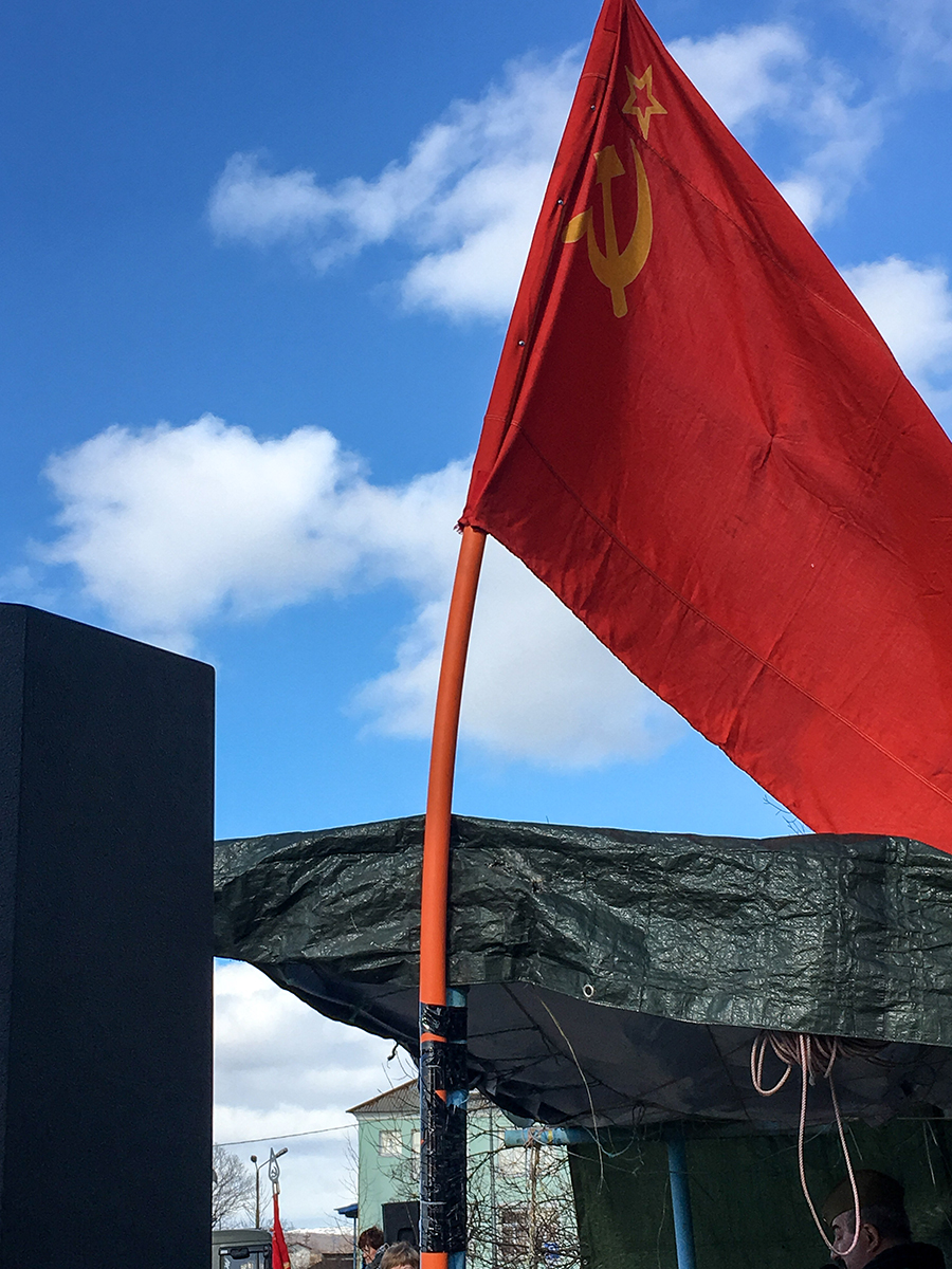 The old Soviet flag waves in the breeze on Victory Day.