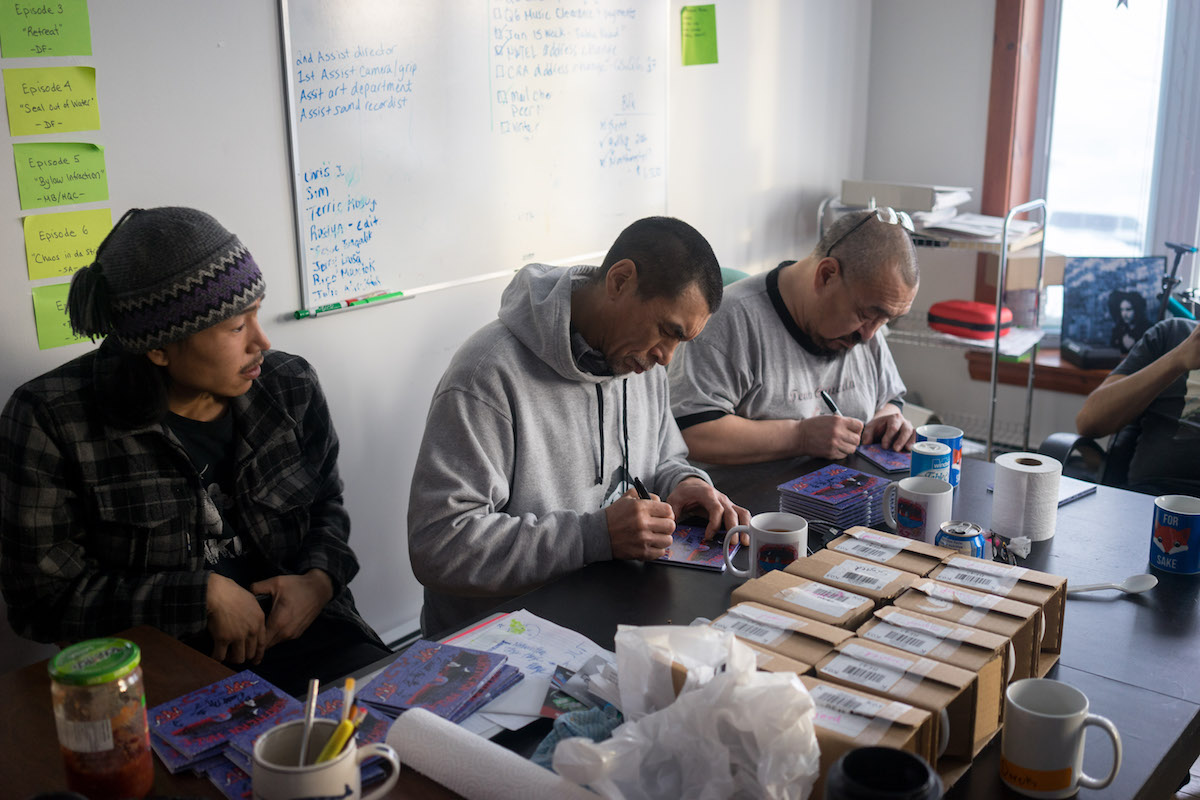 Band members from Northern Haze sign CD covers.