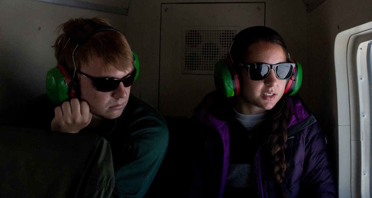 Graduate students Ian MacDowell and Rosie Leone look down on the ice sheet from inside the helicopter.