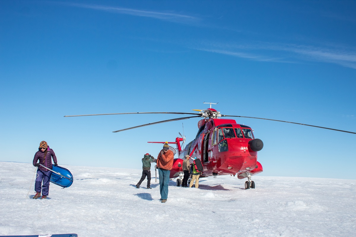 A team of three professors and three students unload the helicopter at their research site on the Greenland ice sheet.
