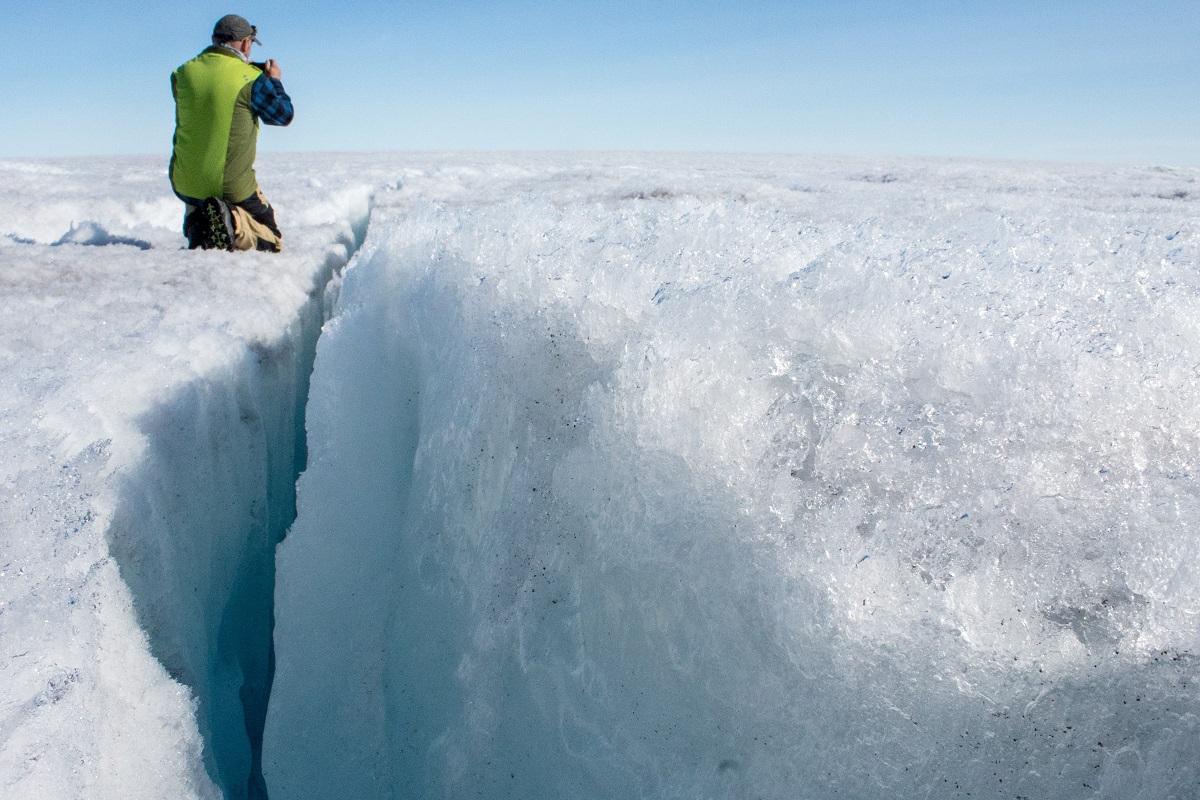 University of Montana glaciologist Joel Harper examines a deep crack in the ice sheet called a crevasse.