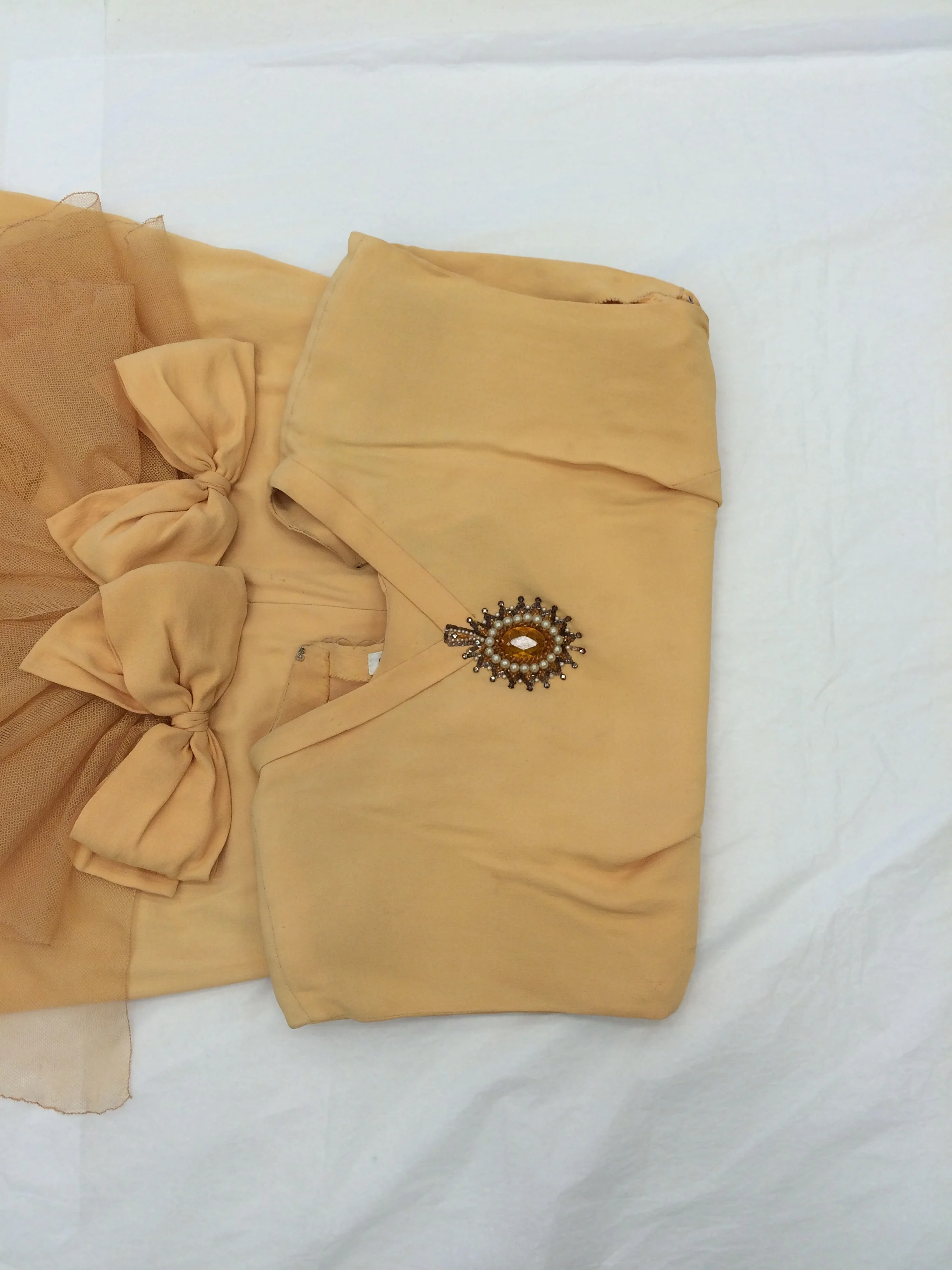  A beaded medallion replaced the need for a necklace, but after all these years, it had put some stress on the fabric of the dress 