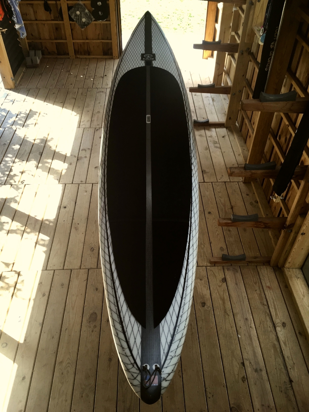 We had just finished the “Great Hall of the Longboats” and a picture of South Carolina custom shaper Ian Balding holding out the first one of these boards popped up in my facebook feed (posted by the Distressed Mullet). Like some art freak that sees the perfect Jackson Pollock for their study I HAD TO HAVE ONE!! Allot of people Identified this stand up paddle board as a downwind board...but I instantly saw it as something else: A long range SUP surfboard. Here on the east coast when the big storm swells come in and our beaches are closed out by distant tropical storms or the aftermath of Nor'Easters we often look out into our inlets, or down from long bridge crossings and longingly gaze into the mauls of mysto breaks that are way out of range of standard surf craft including the wafer like SUP surf boards that have come to pervade the beach breaks. (See first island video) The Albatross is made for these dreams. Every part of this hand shaped board, from its beautifully extreme rocker profile to its side biter fins, to its double leash plug exudes traversing large expanses of big water in order to slip into off shore breaks. I think this was the second or third Albatross shaped and signed by Ian. It comes in a custom Vitamin Sea bag with an FSC Hawaii downwind fin, a FSC Jerry Lopez large surf center fin and two side biters. The fact is that while I am an avid surfer I am not a particularly accomplished (or brave) surfer. When I bought the Albatross I labored with the opinion that big offshore waves could not be truly “surfed” in a ski, that without rail and fin no real inspired line could be drawn in this realm. Inspired by the likes of the South African Mocke brothers I started to look for the right waves in a ski. After about or 3rd solid groundswell of this year I realized that when ever it got really big, To big to surf my 9' 6”, I was going to always be in a surf ski. As much as this board makes a classy table for a fine selection of wines out in the boathouse it deserves to be cut loose to ride the monsters out on the outer shoals and spread its wings like the great seabird bird whose name it carries.