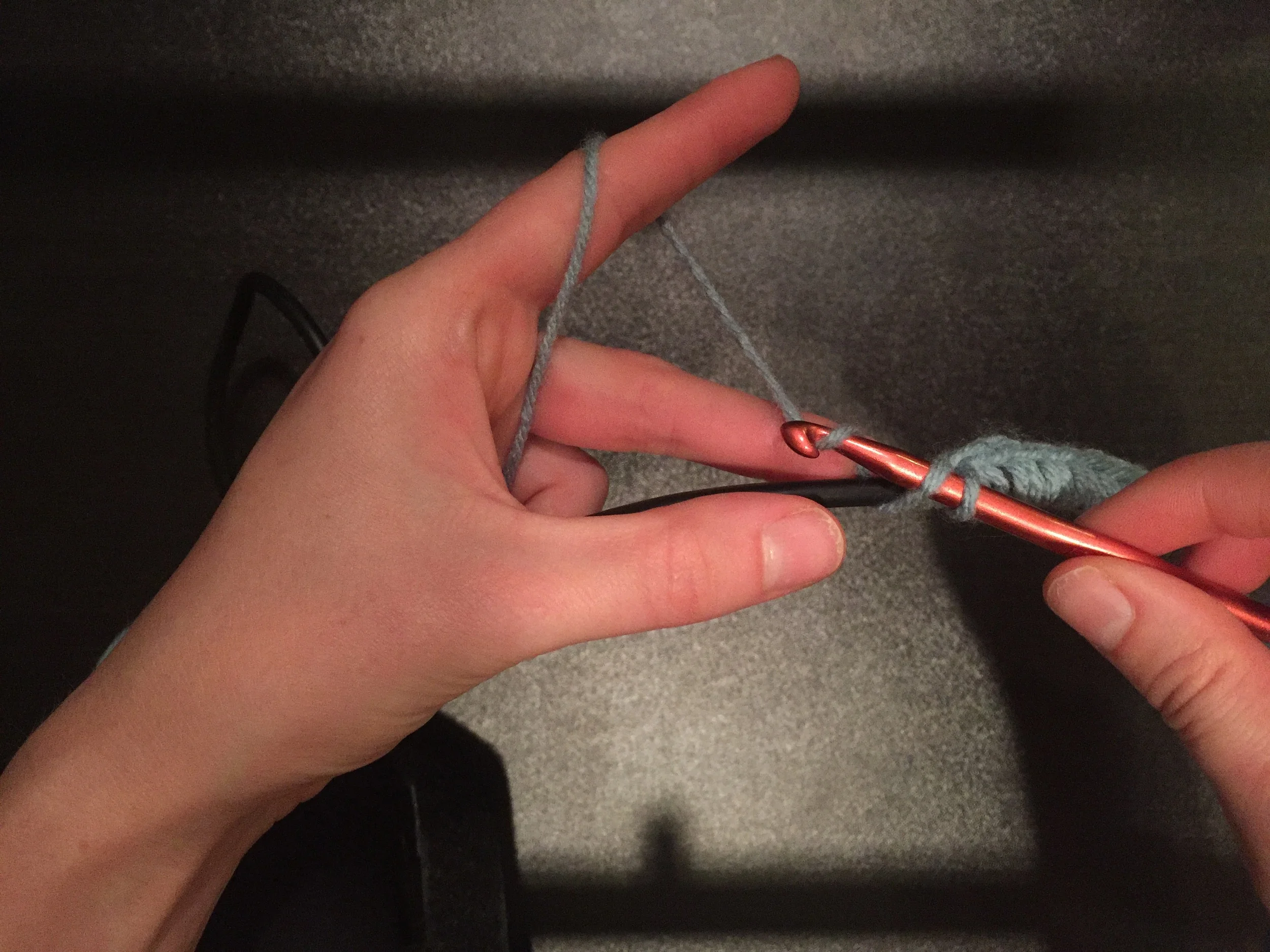 Hook a bit of the yarn to pull it through both loops on your needle.