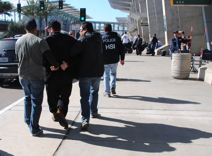 Joel A.Wright, second from left, was arrested at the San Diego airport on Friday. Credit: U.S. Immigration and Customs Enforcement, via Associated Press