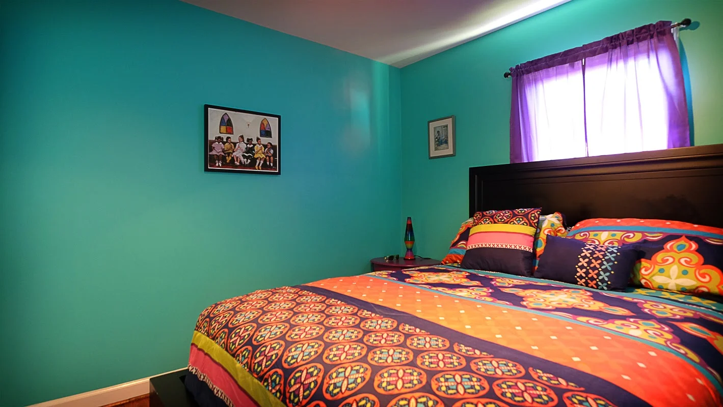 Teal walls against multicolored bed spread - Residential painting by Nash Painting Nashville TN