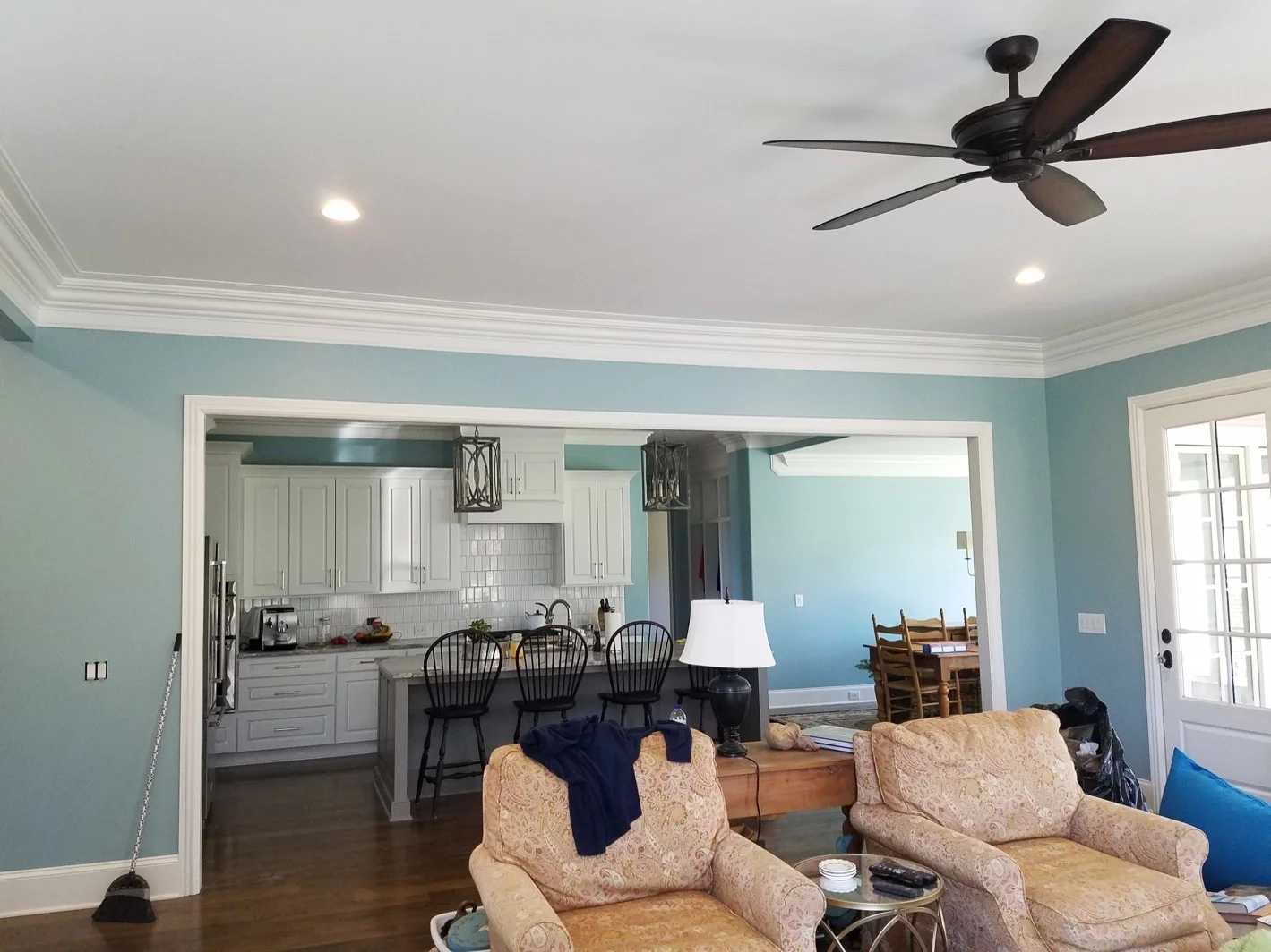 Blue living room and kitchen with white cabinets and trim - Residential painting by Nash Painting Nashville TN