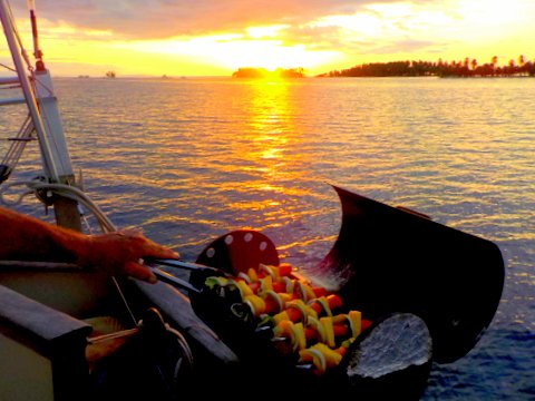 Grilling chirizoe kabobs with fresh pineapple at sunset