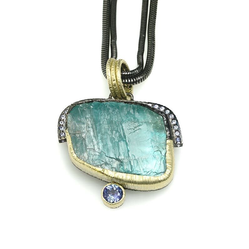 Rough stones are some sensational  in my opinion. Amazing colour and texture in this statement pendant. 18k Recycled Green Gold, Stering Silver black Rhodium plated and Tanzanites to pair the big Rough Aquamarine. A layer or mother of pearl under the