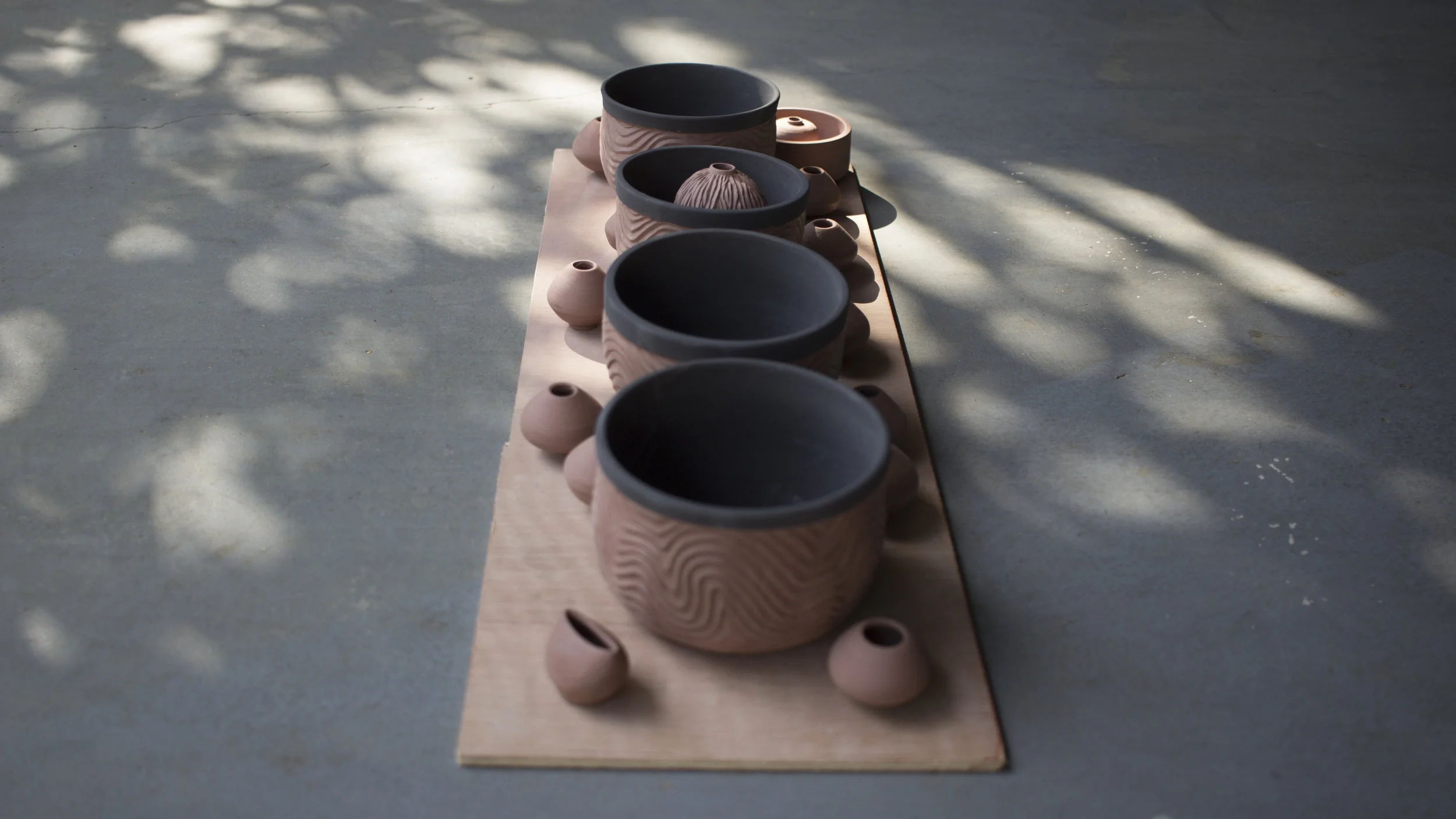 Greenware bowls and tiny pots ready to be loaded in the kiln.