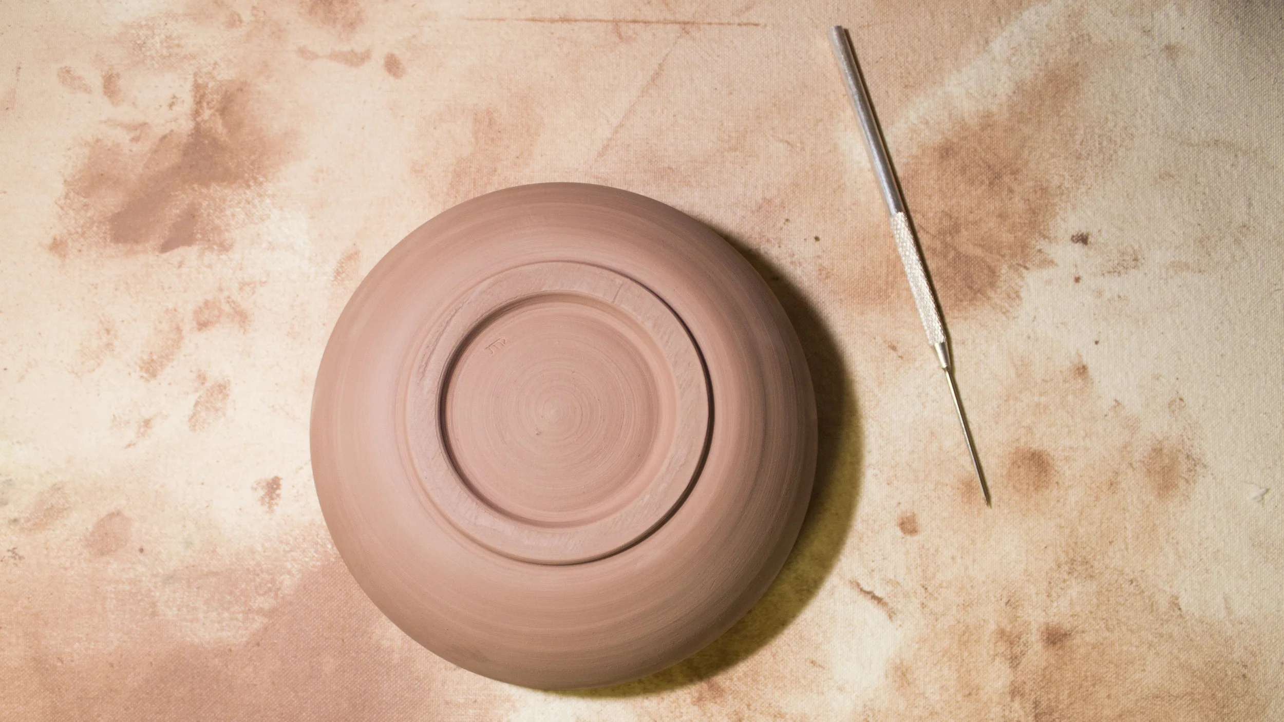 Applying the final touch to the piece, my initials.