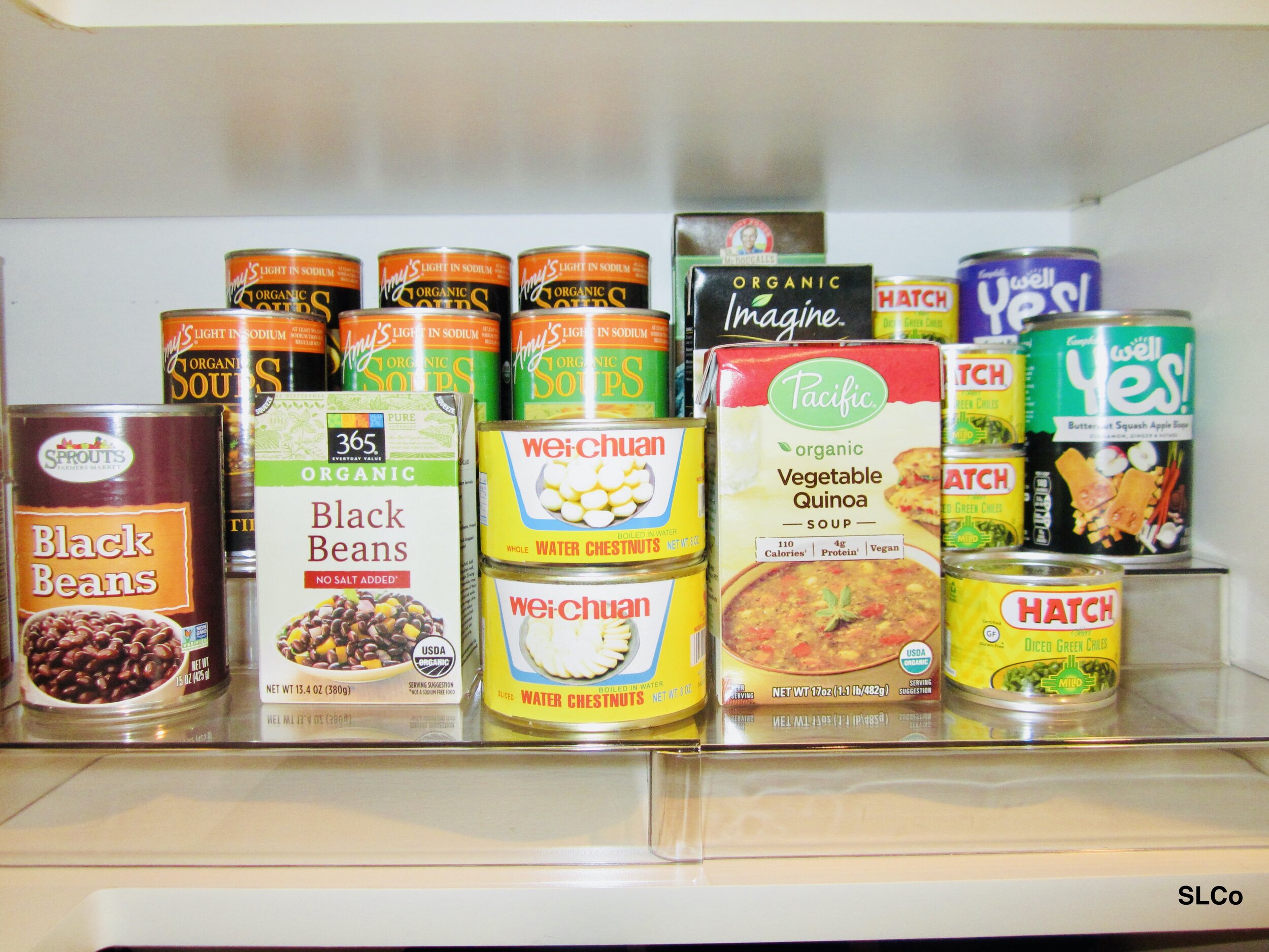 Canned beans and other items on a shelf layered for access