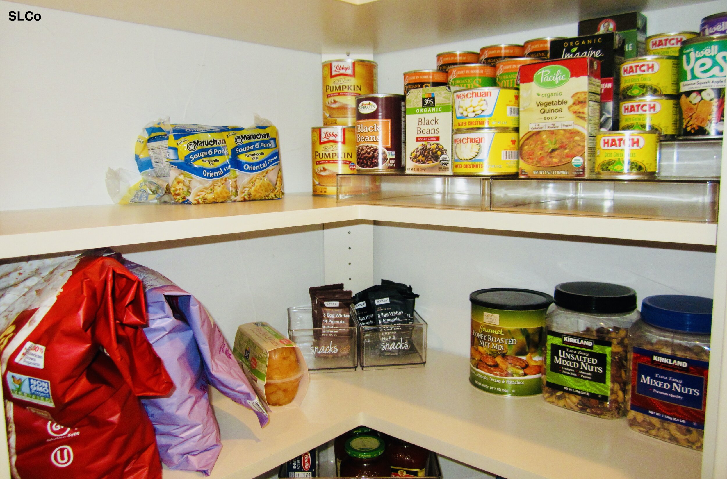 Canned beans and other items on a shelf layered for access and extra space on the other shelves