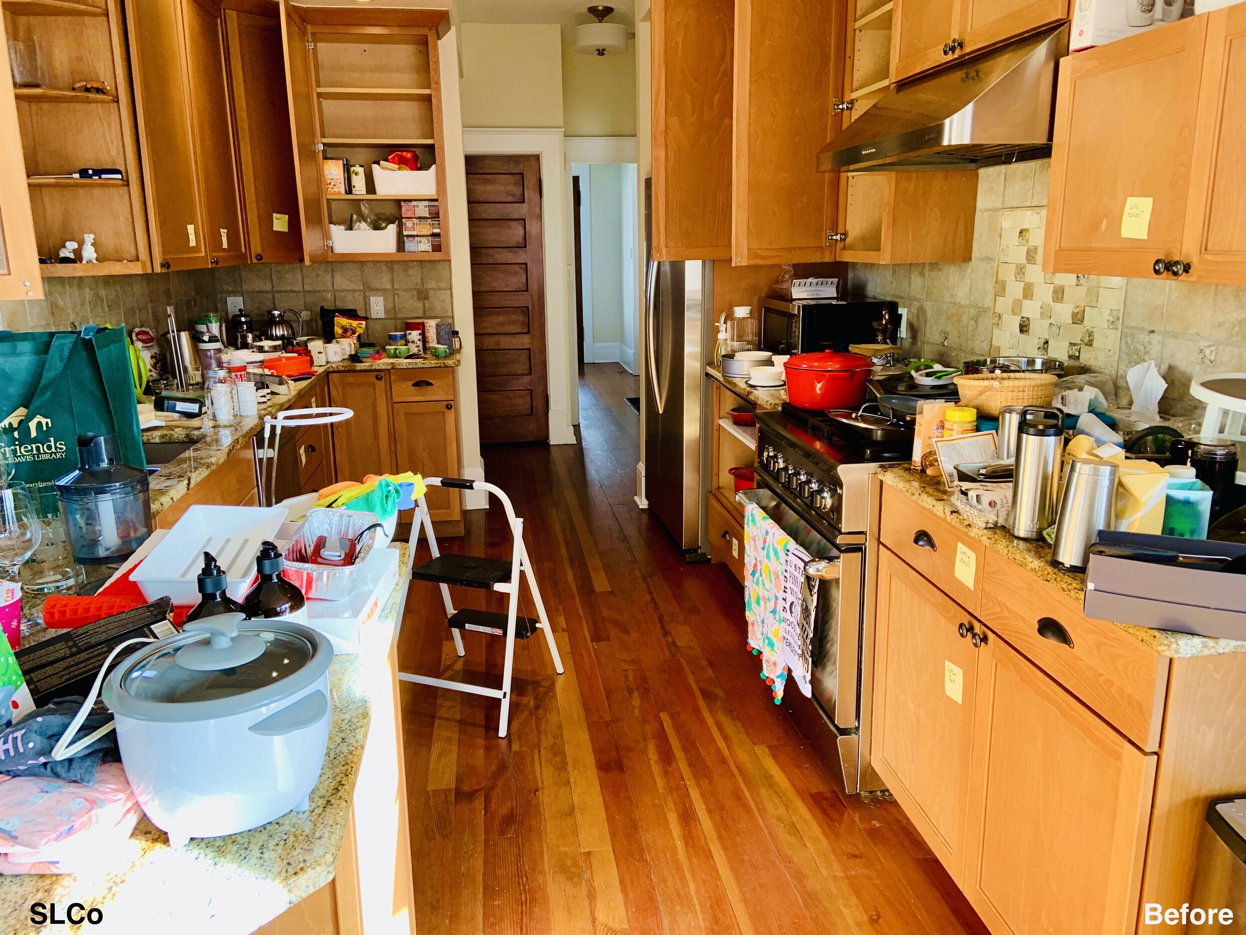 Wooden kitchen with items on counters and floors