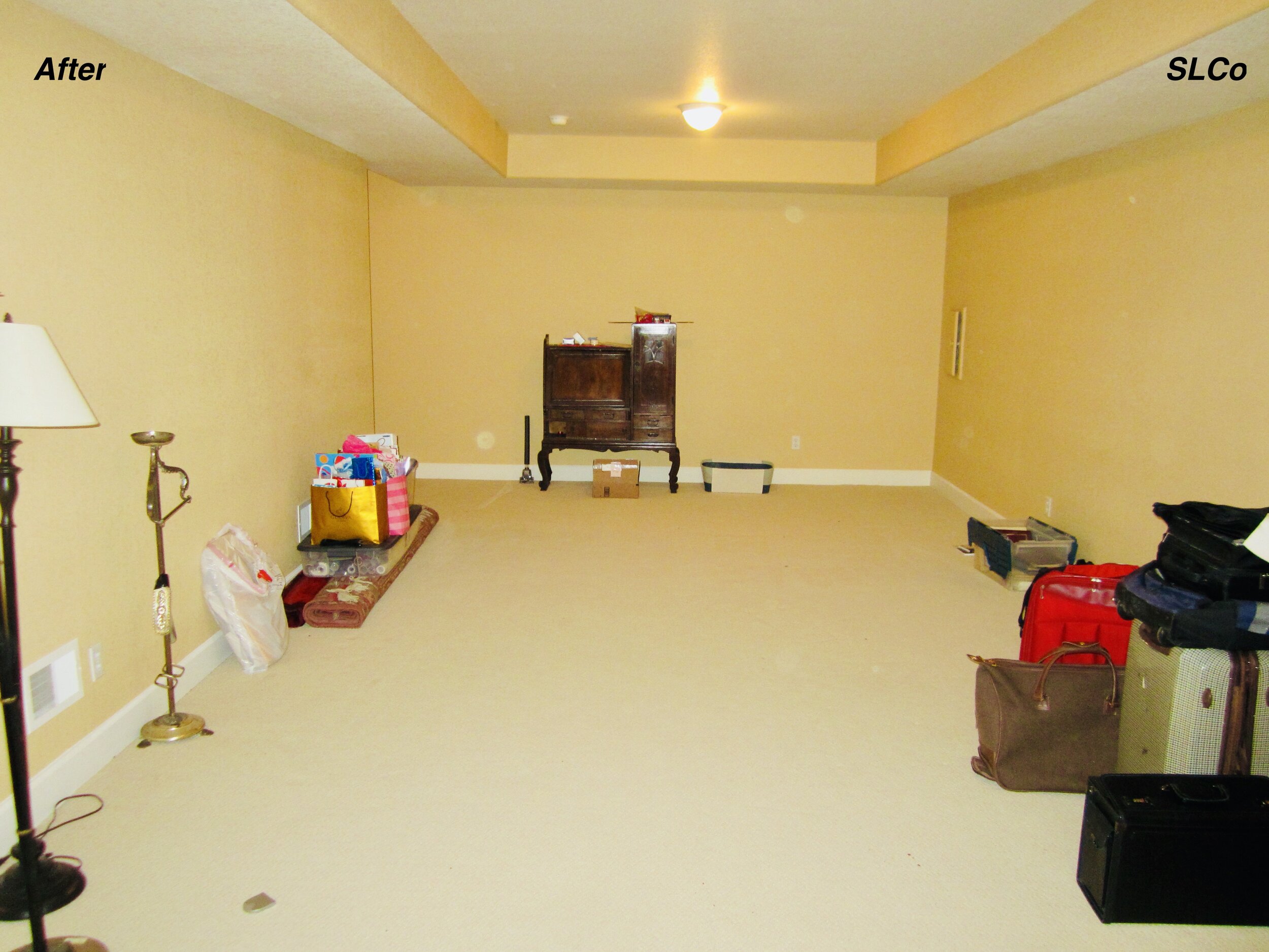 After photo of large basement with boxes and containers clear, some luggage against wall, and floor clear.