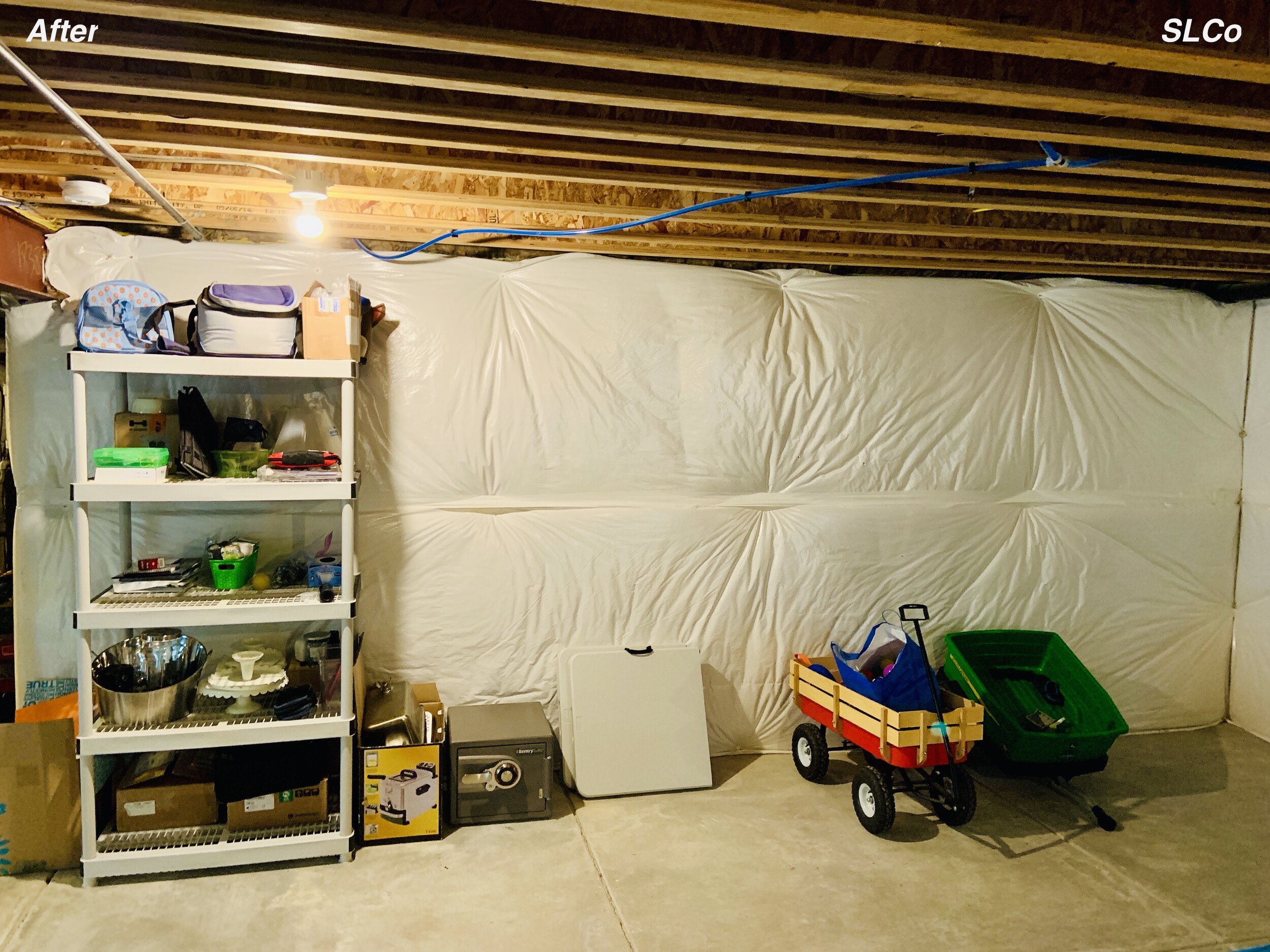 After photo of unfinished basement with white shelving unit with items organized on it and floor clear.