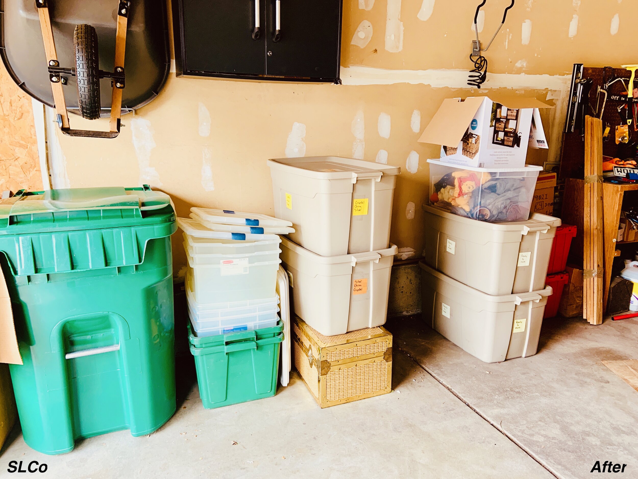 After photo of garage with green trash bins, no moving boxes, and containers labeled and ogranized.