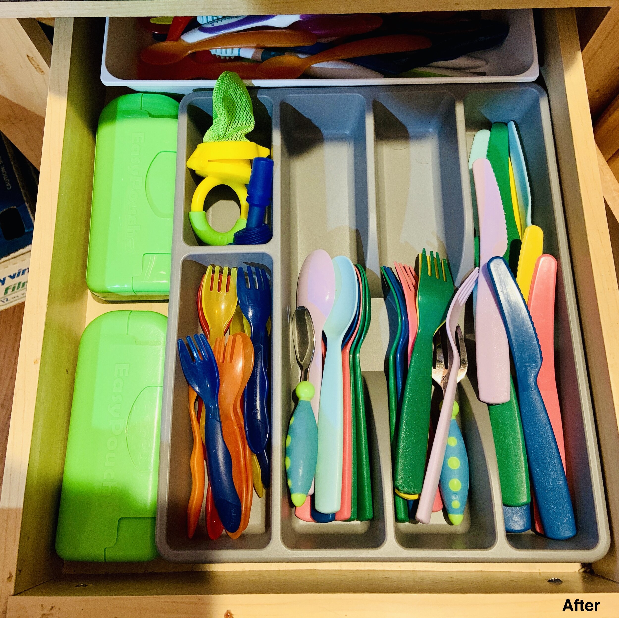 Kitchen silverware drawer with silverware in their own space using a silverware container.