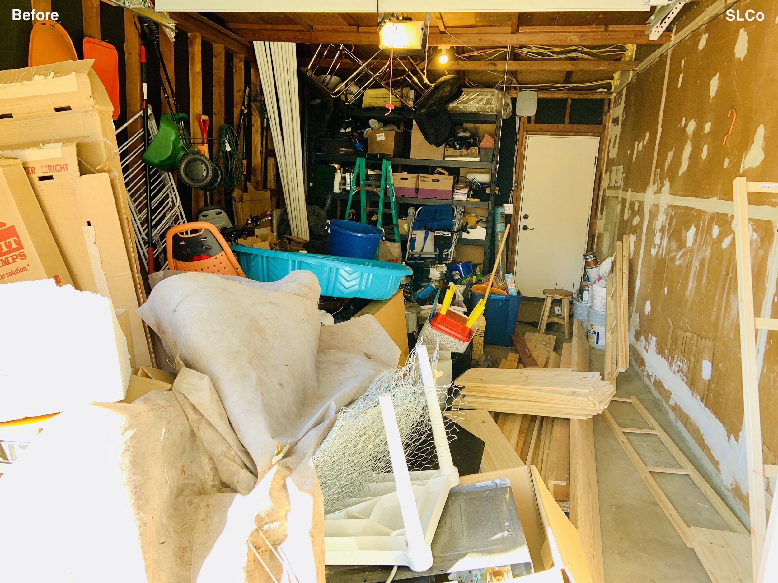 Before photo of unusable garage filled with wood and bins, unwalkable and view from garage door