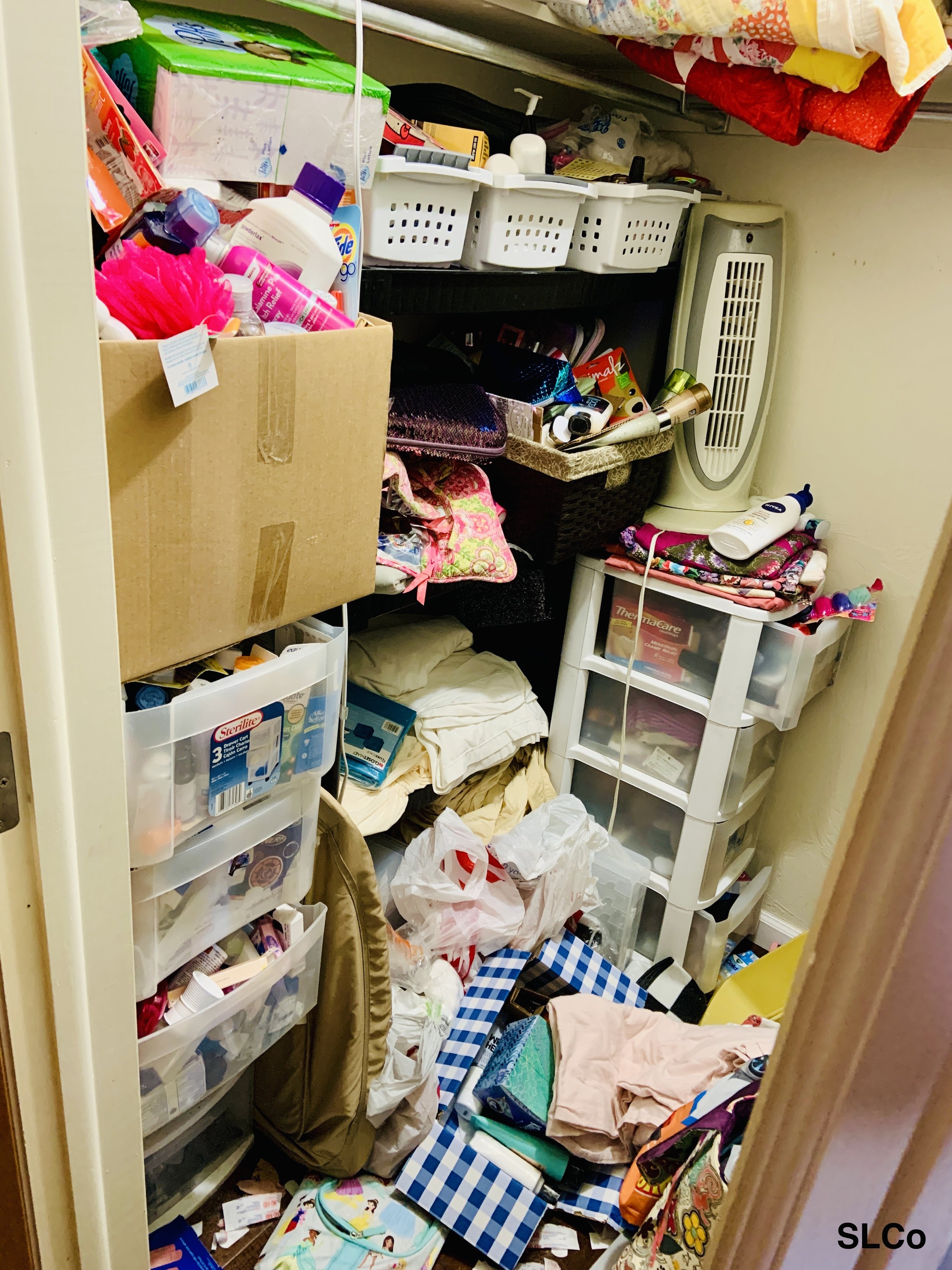 Before photo of Arvada storage closet with containers and shelves overflowing with linens, clothes, containers and a fan.