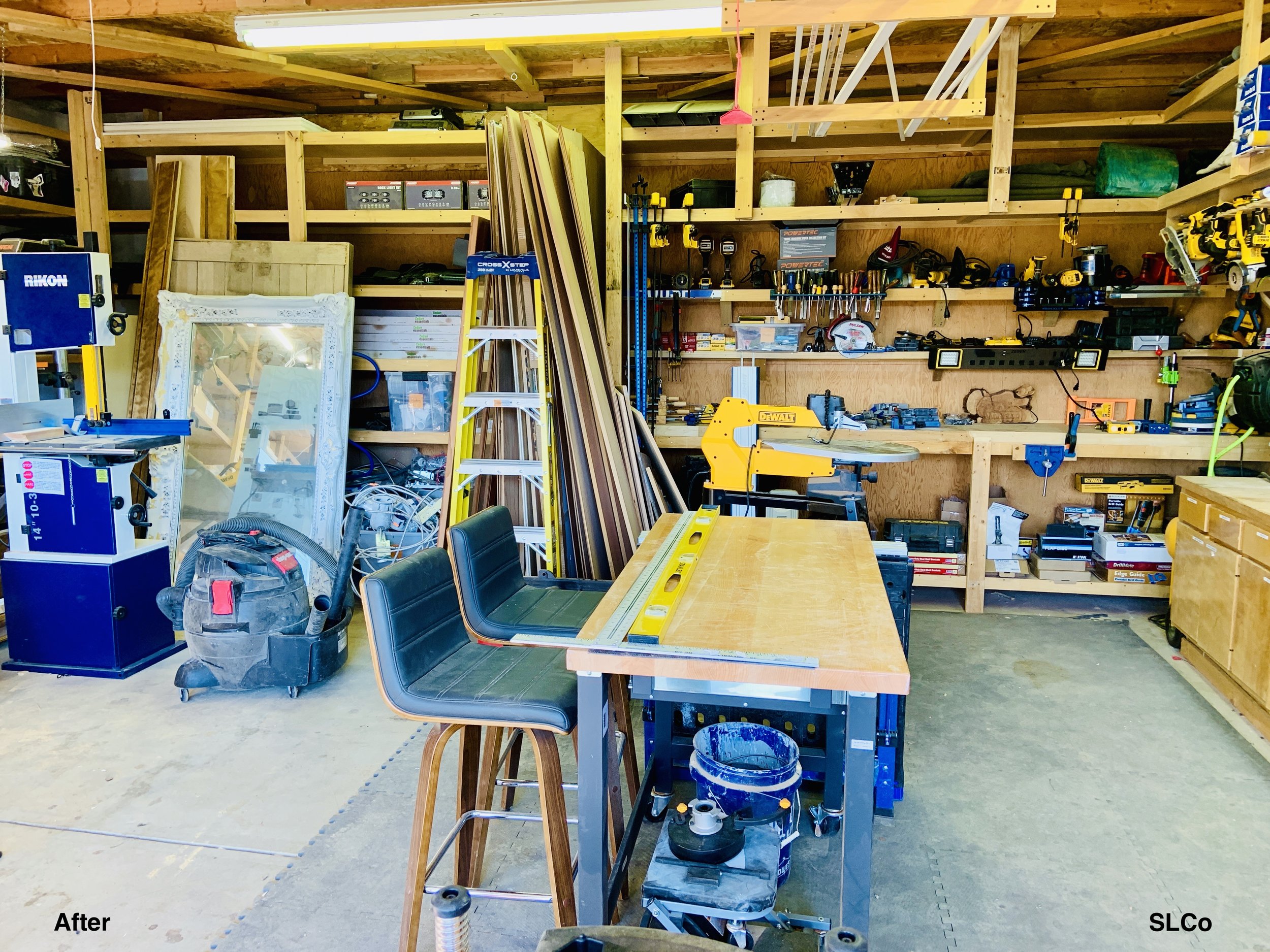 Workshop with wooden counters clear, tools in homes and organized and table in the front clear with rulers on it.