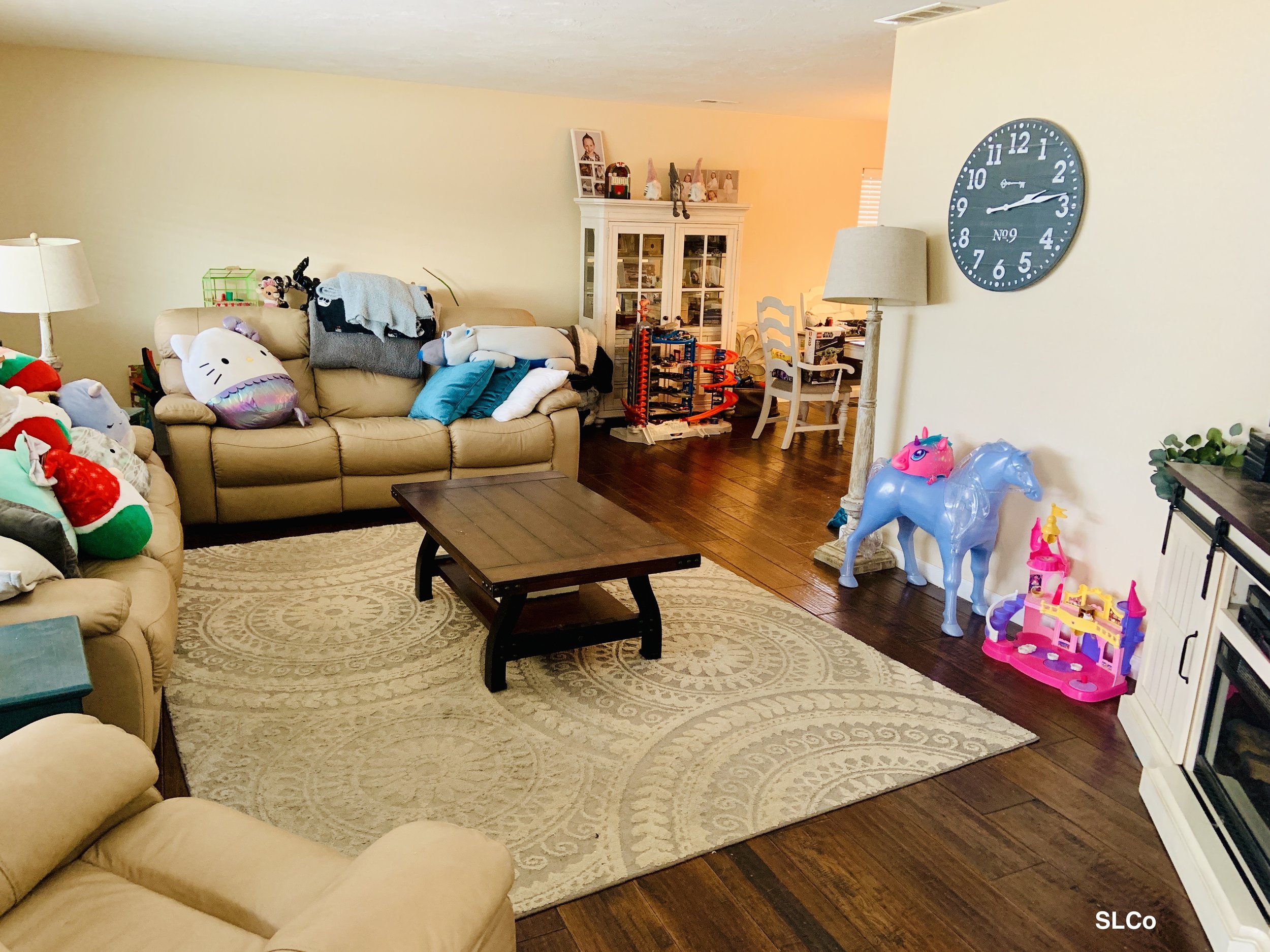 Smaller living room with two couches with pillows on them and toys to the side, floor clear.