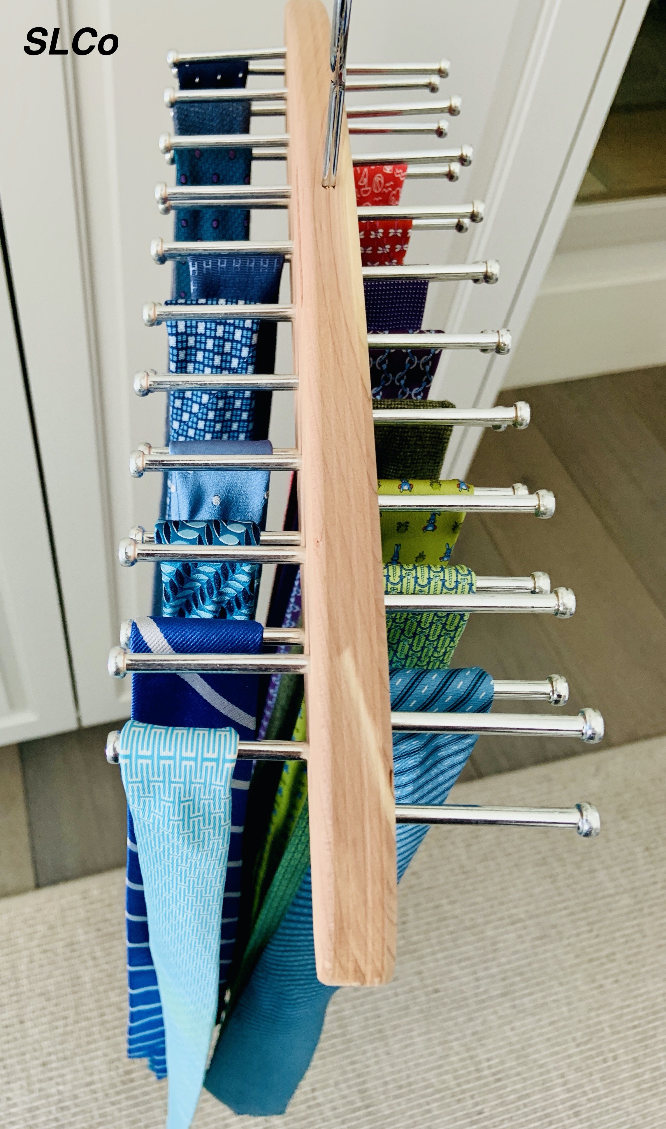 Tie hanger overhead view of ties on their own hooks on a wooden hanger.