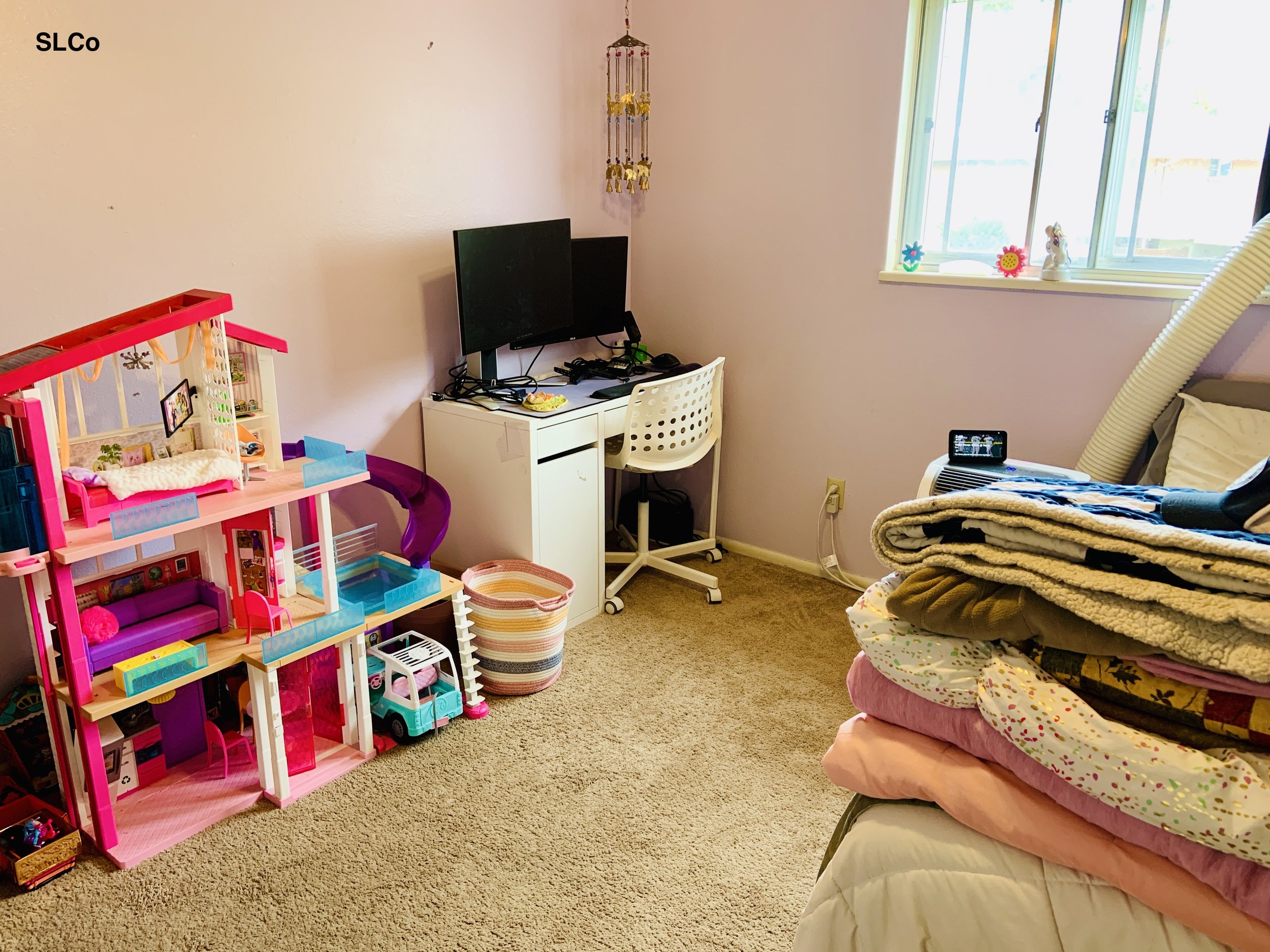 Bedroom with floor clear, small desk organized with computer, and kids dollhouse cleaned