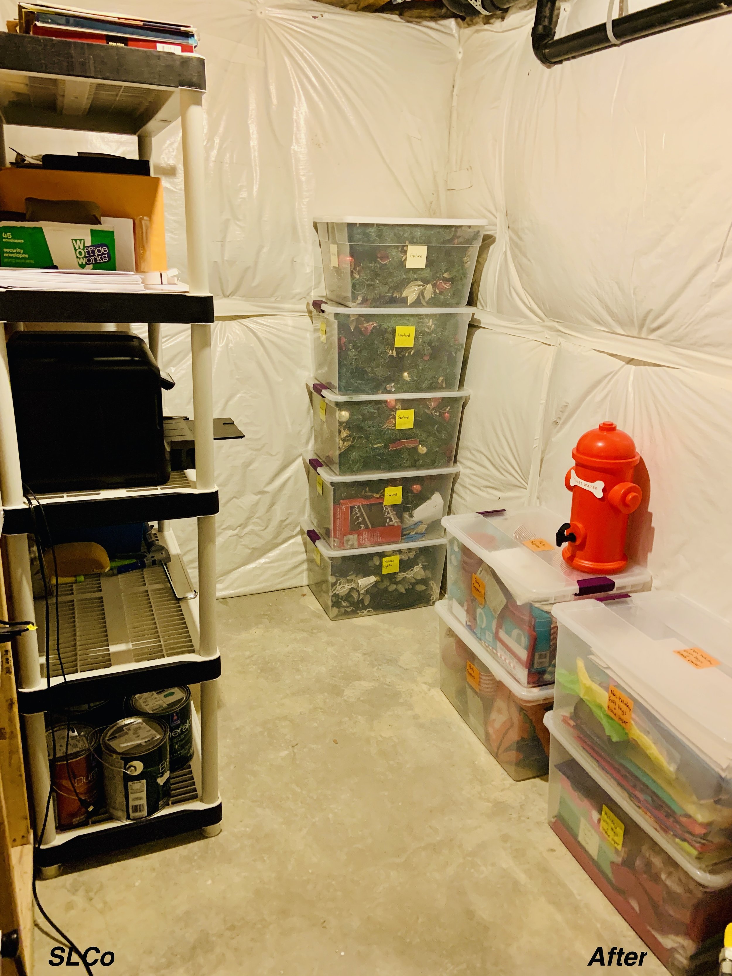 After photo of unfinished basement with clear containers stacked in corner and floor clear.