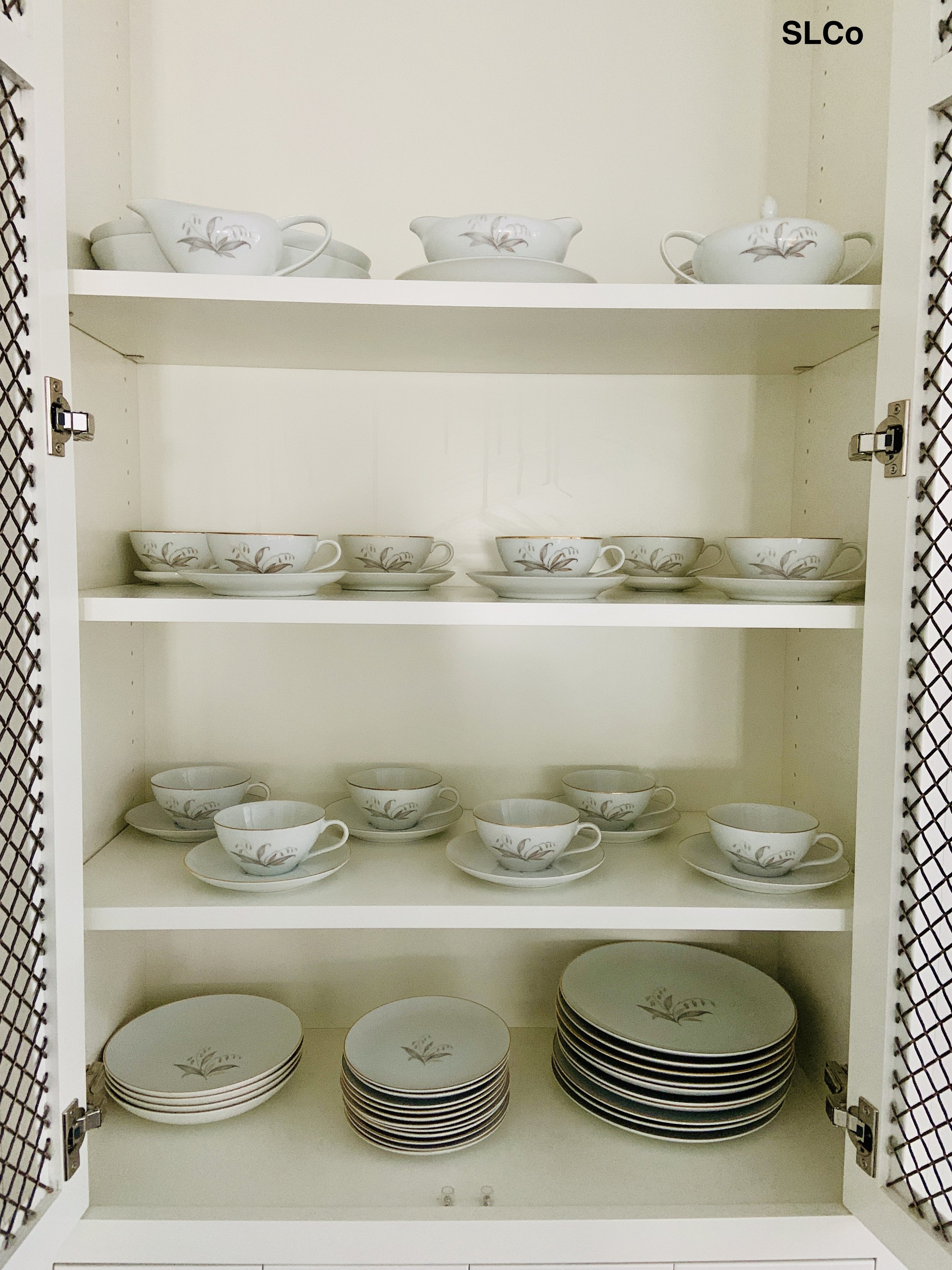 Teaware neatly places on drawers in a cabinet in kitchen