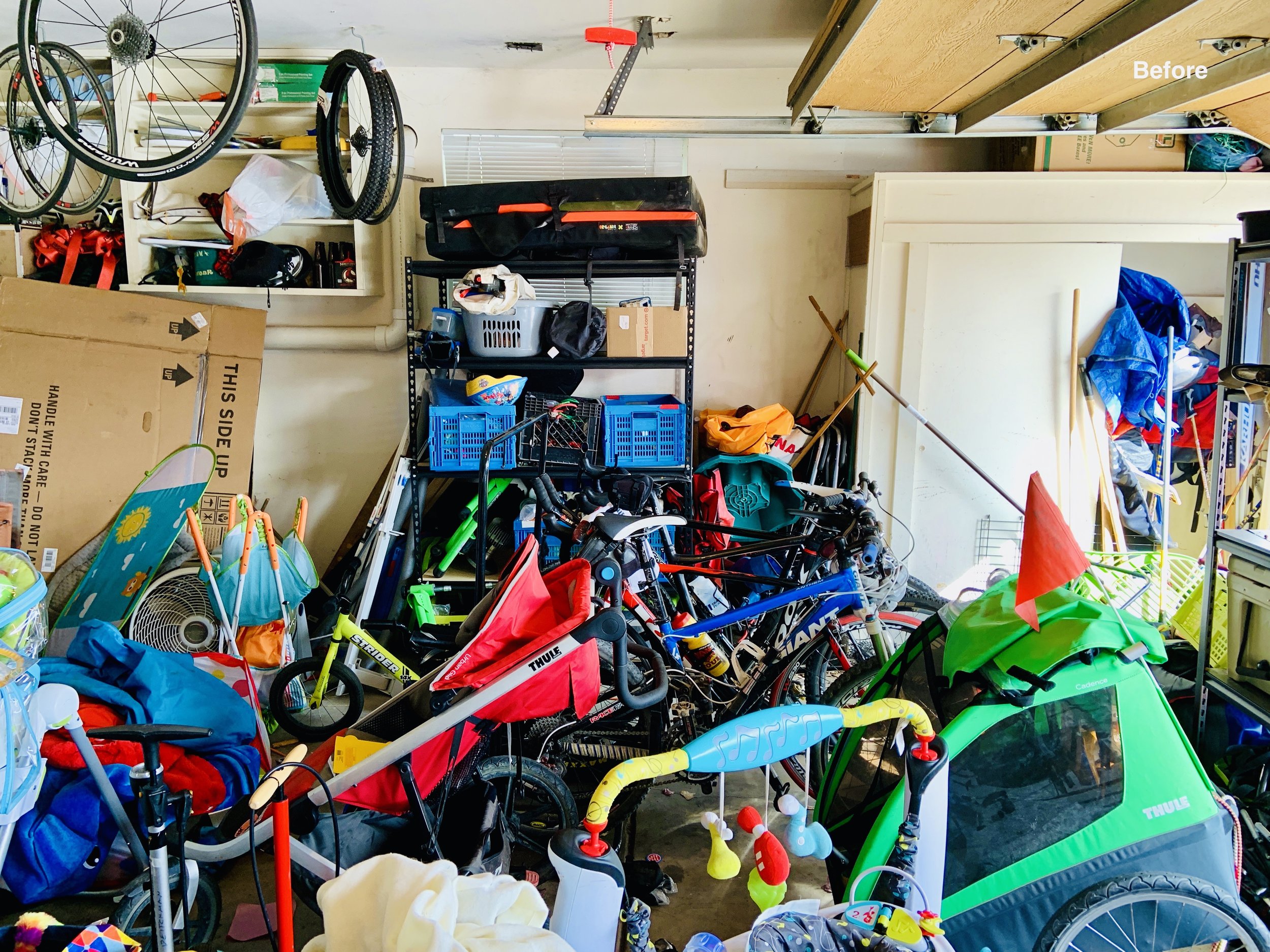 Before photo of garage stacked about 3 ft with strollers, babe items, and moving boxes, unwalkable.