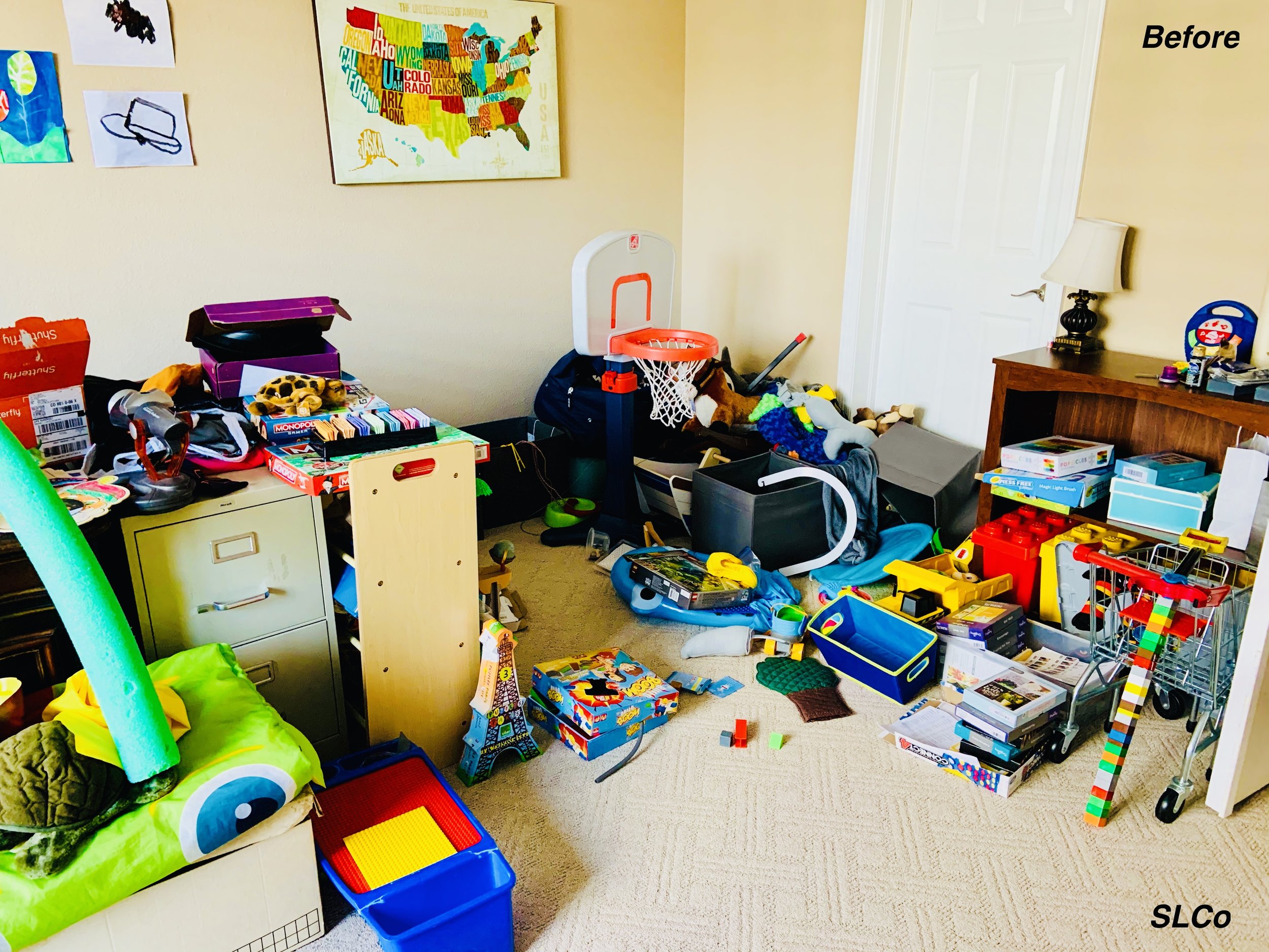 Before photo of playroom with toy boxes and toys on the floor and can't see what items are there stacked on one another.