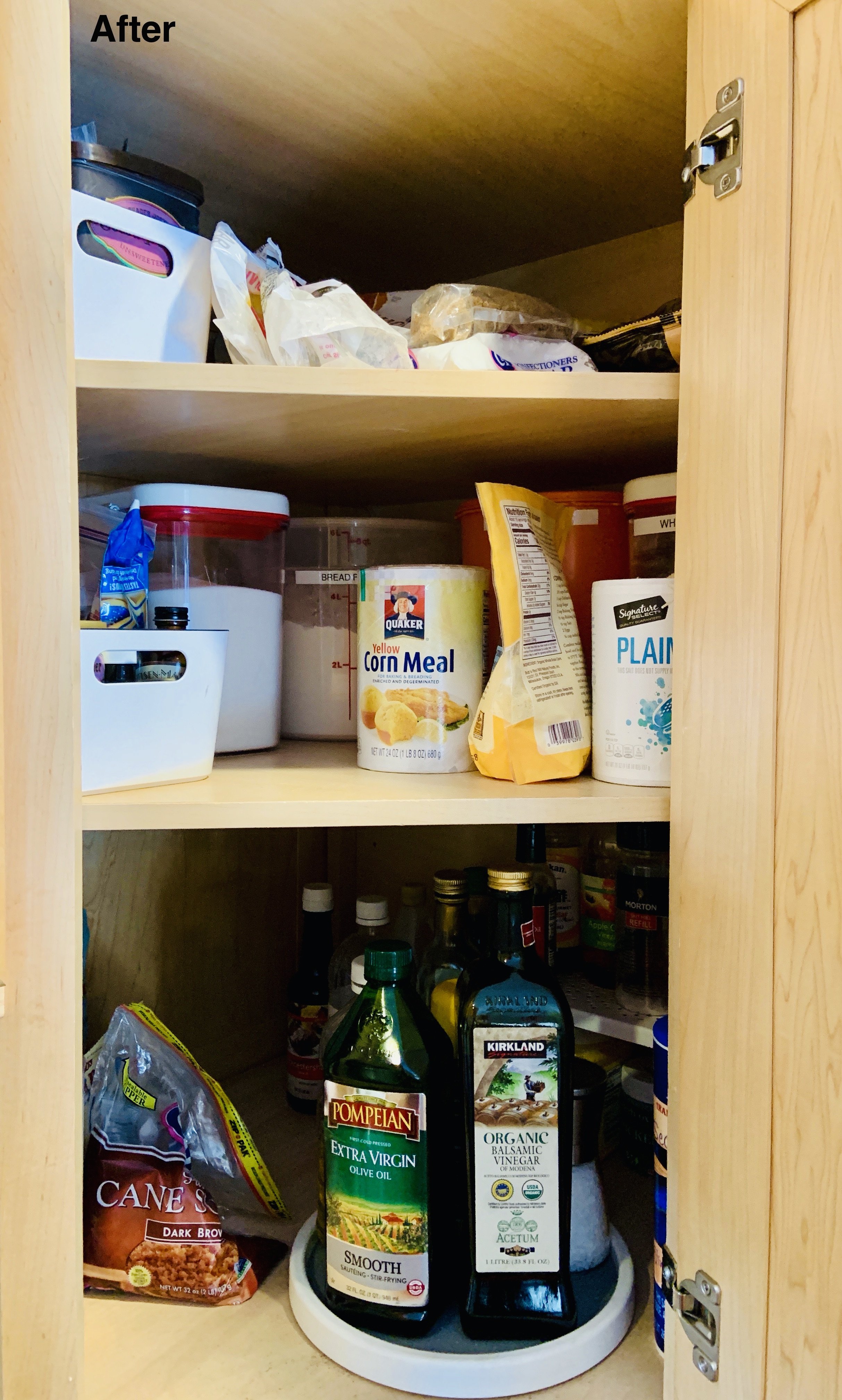 After photo of kitchen cabinet with lazy susan for oils and flours organized on top shelves.