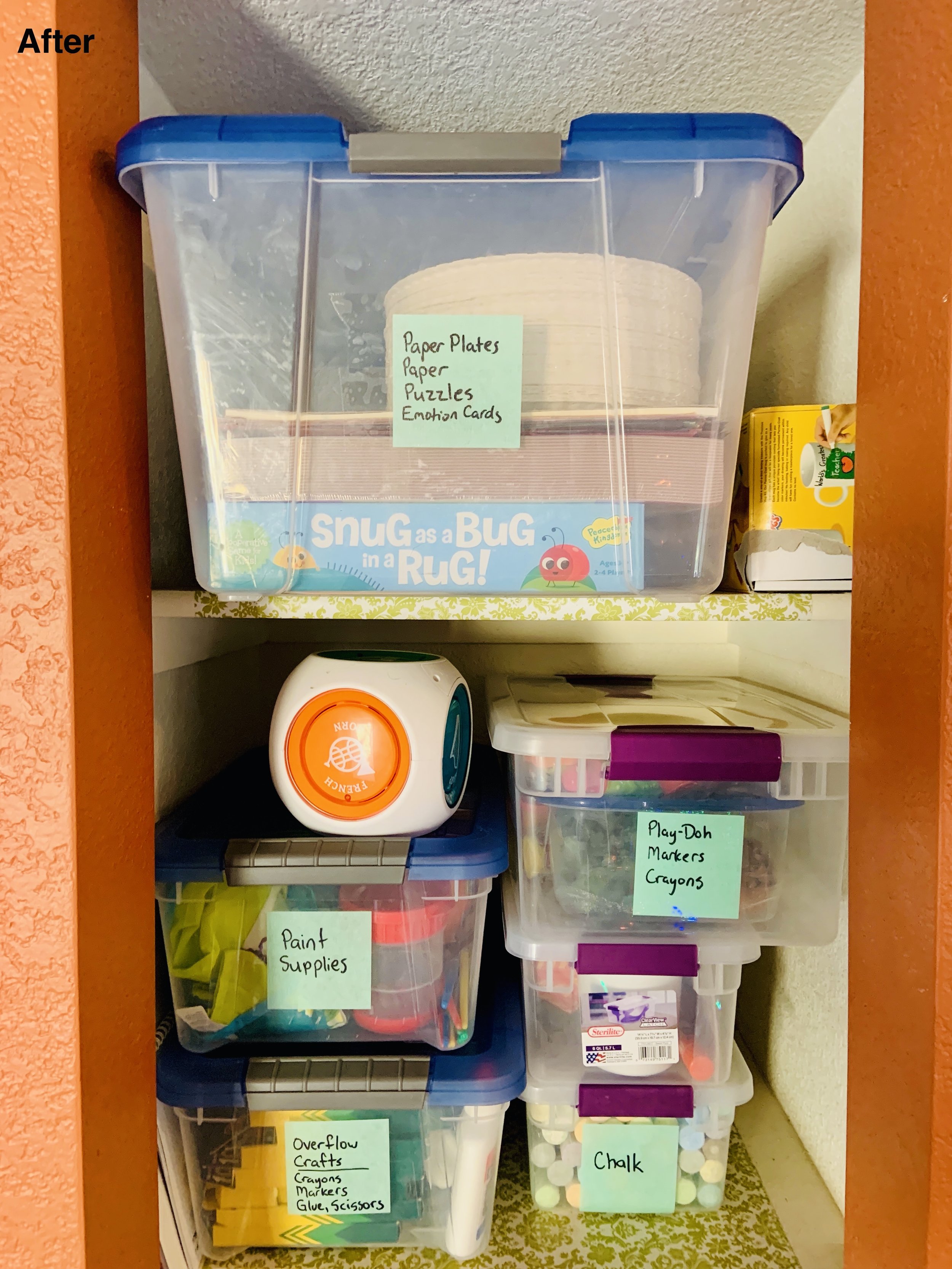 After photo of kitchen cabinet with games and paints and such in their own containers.