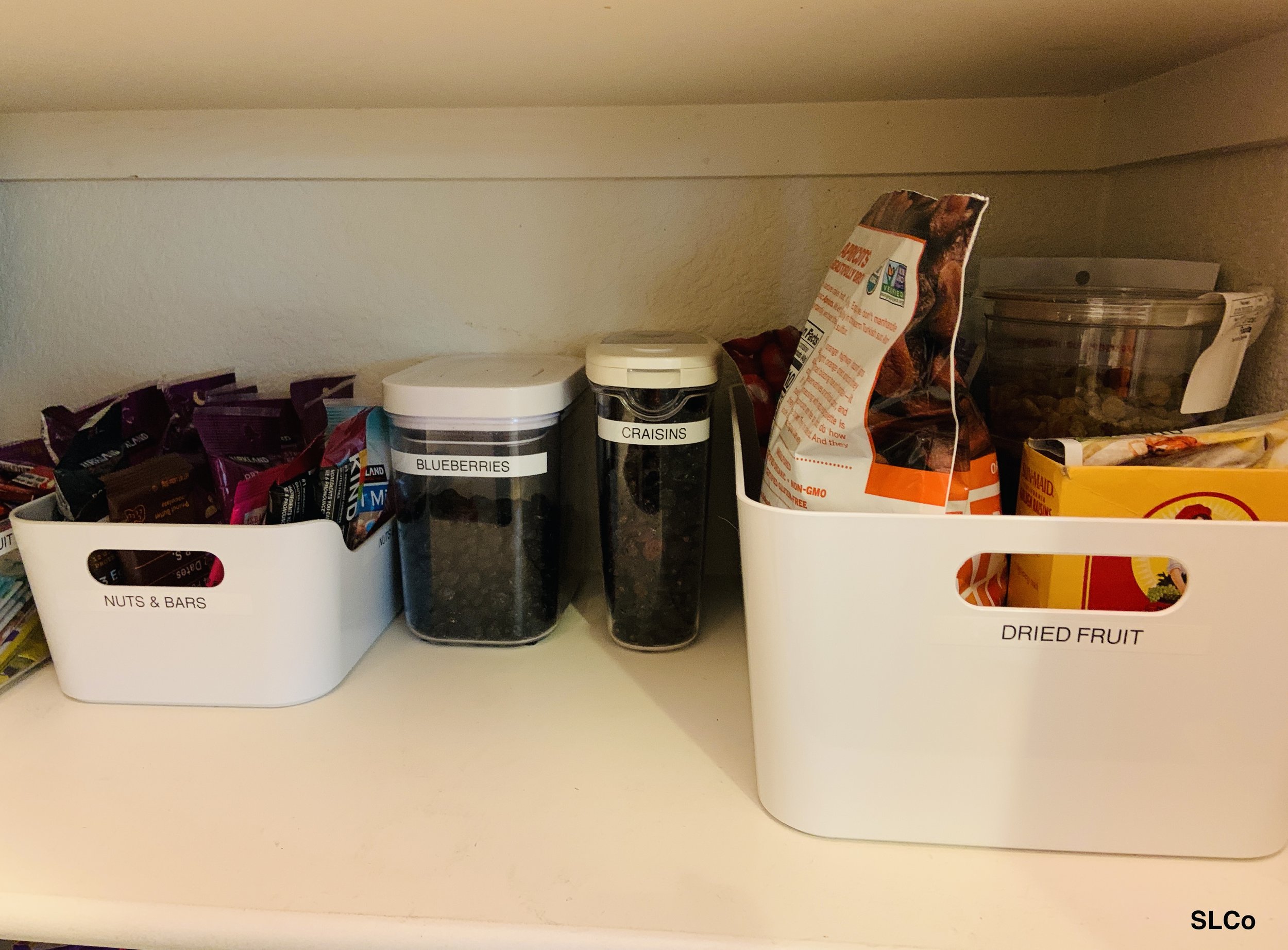 Kitchen shelf with containers labeled for bars and snacks