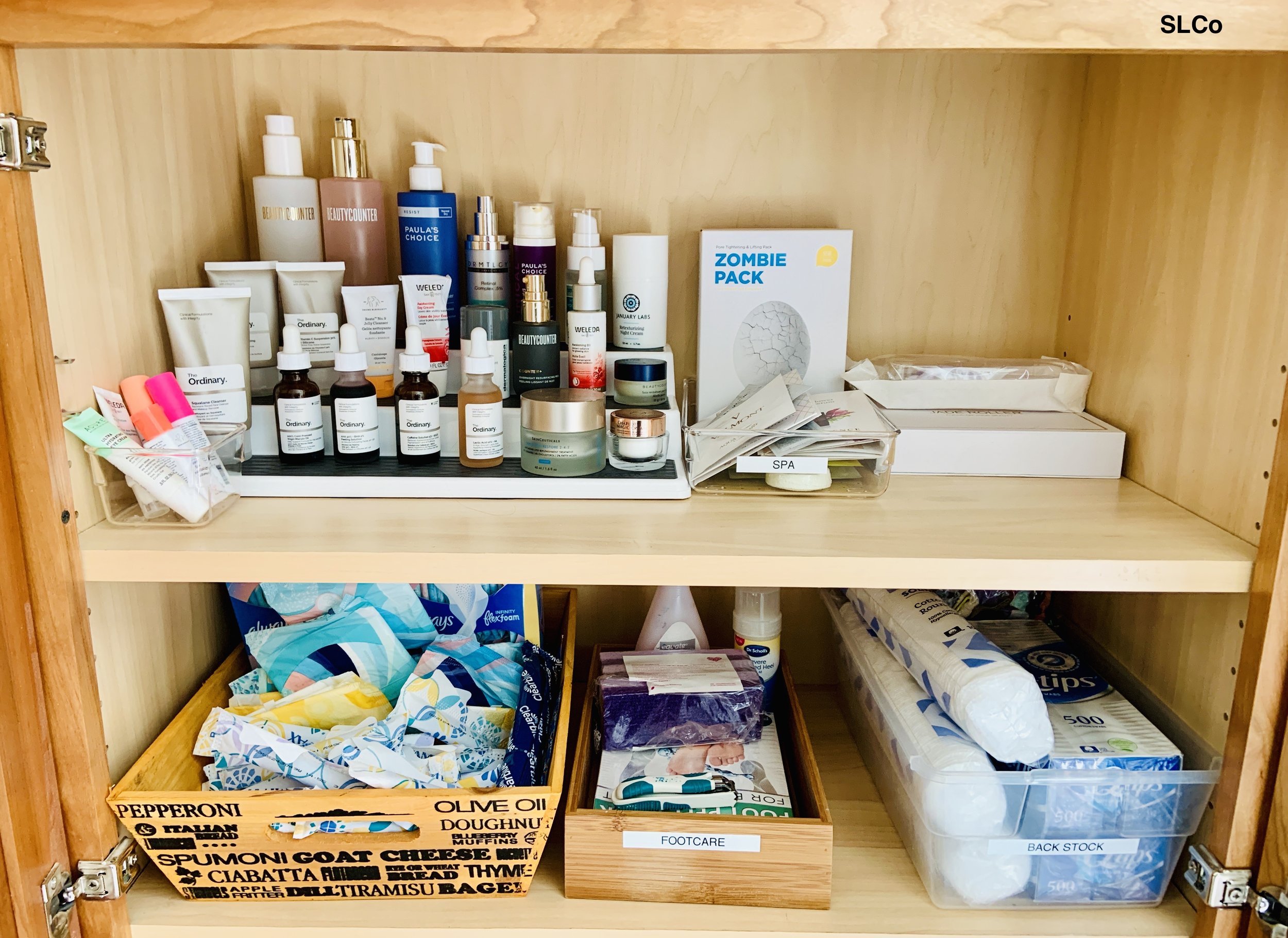 Denver Beauty closet with two wooden shelves with items on a layered shelf and other items in labeled containers.