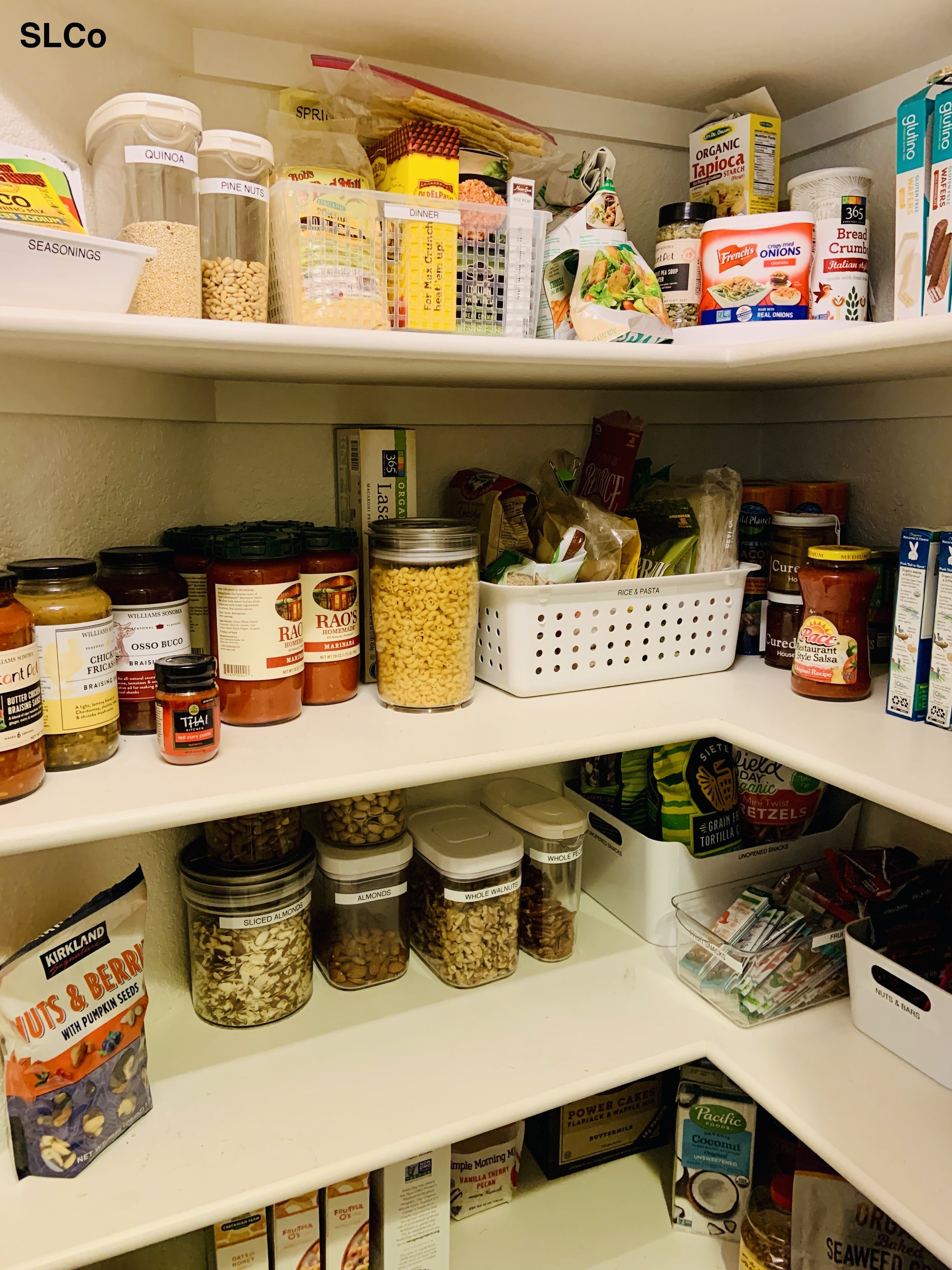 Overview of pantry in kitchen with 4 shelves and items organized in containers.