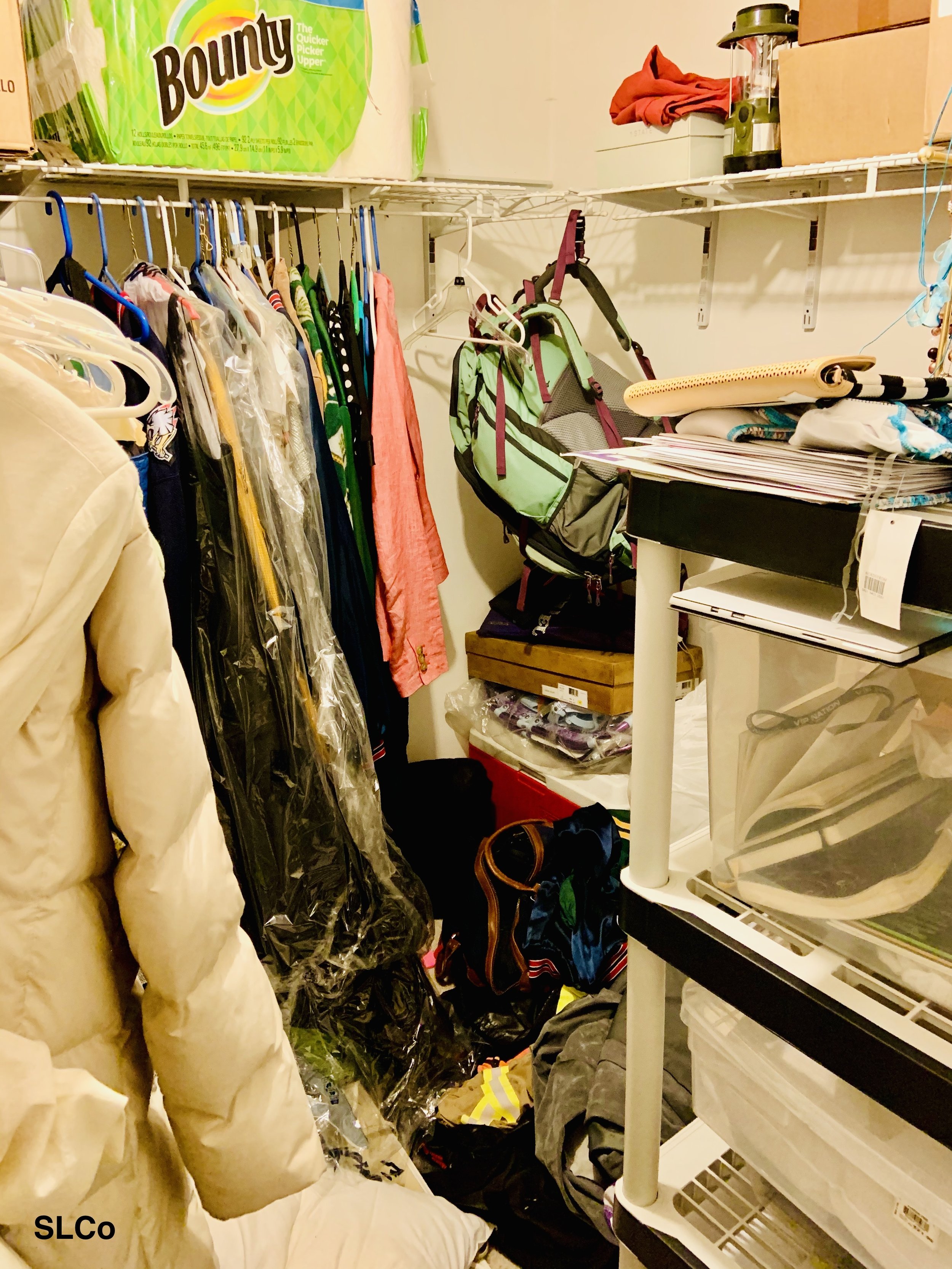 Before image of closet filled with white shelved, clothes and backpacks thrown around.