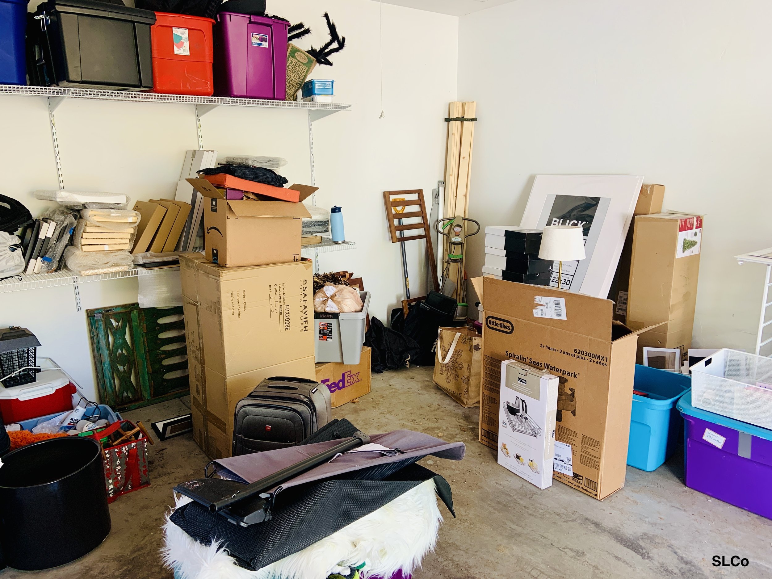 Before photo of corner of garage with boxes on floor