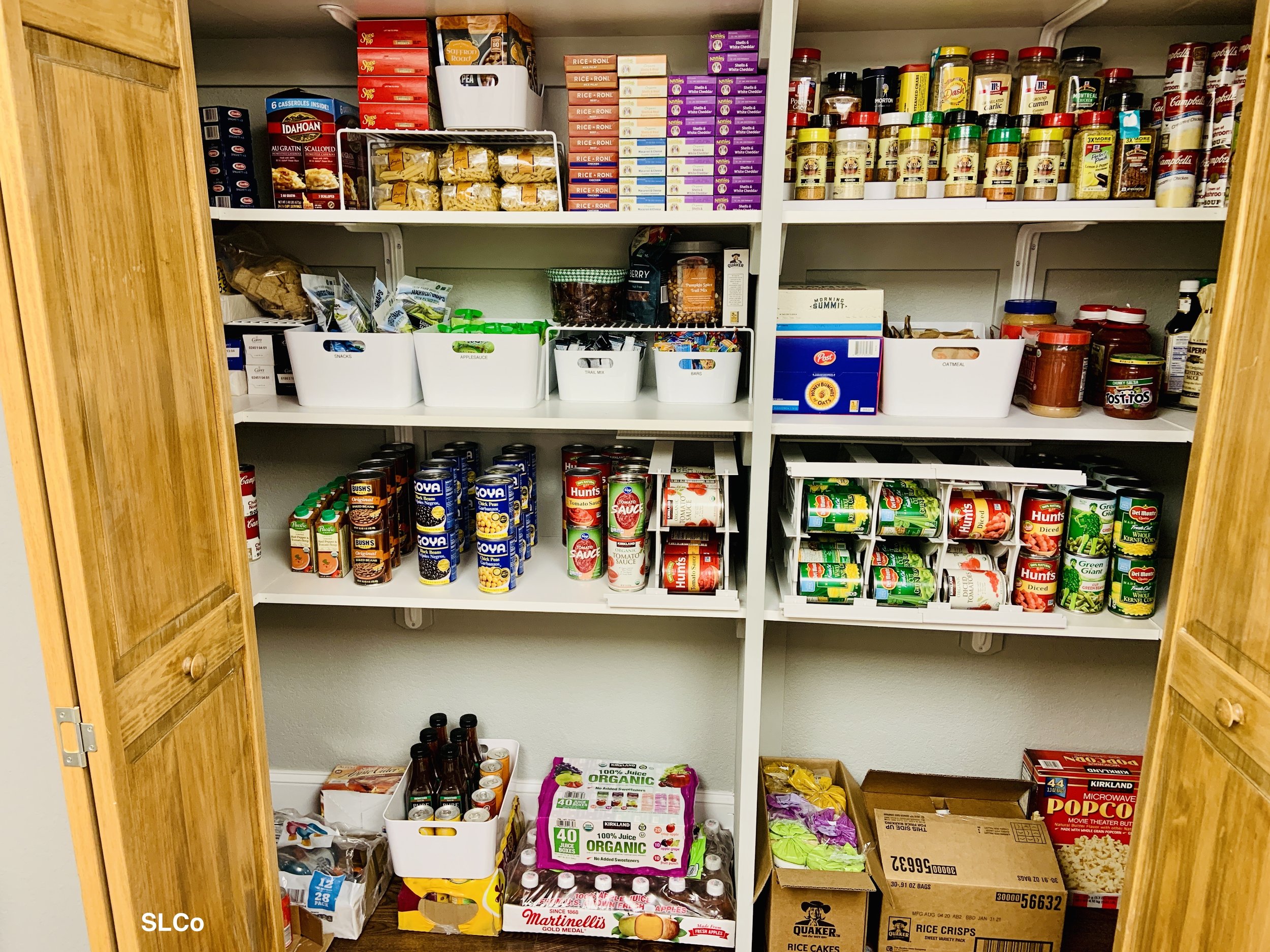 After photo of pantry with four shelves and everything nearly organized with cans, ramen, noodles, spices, and more.