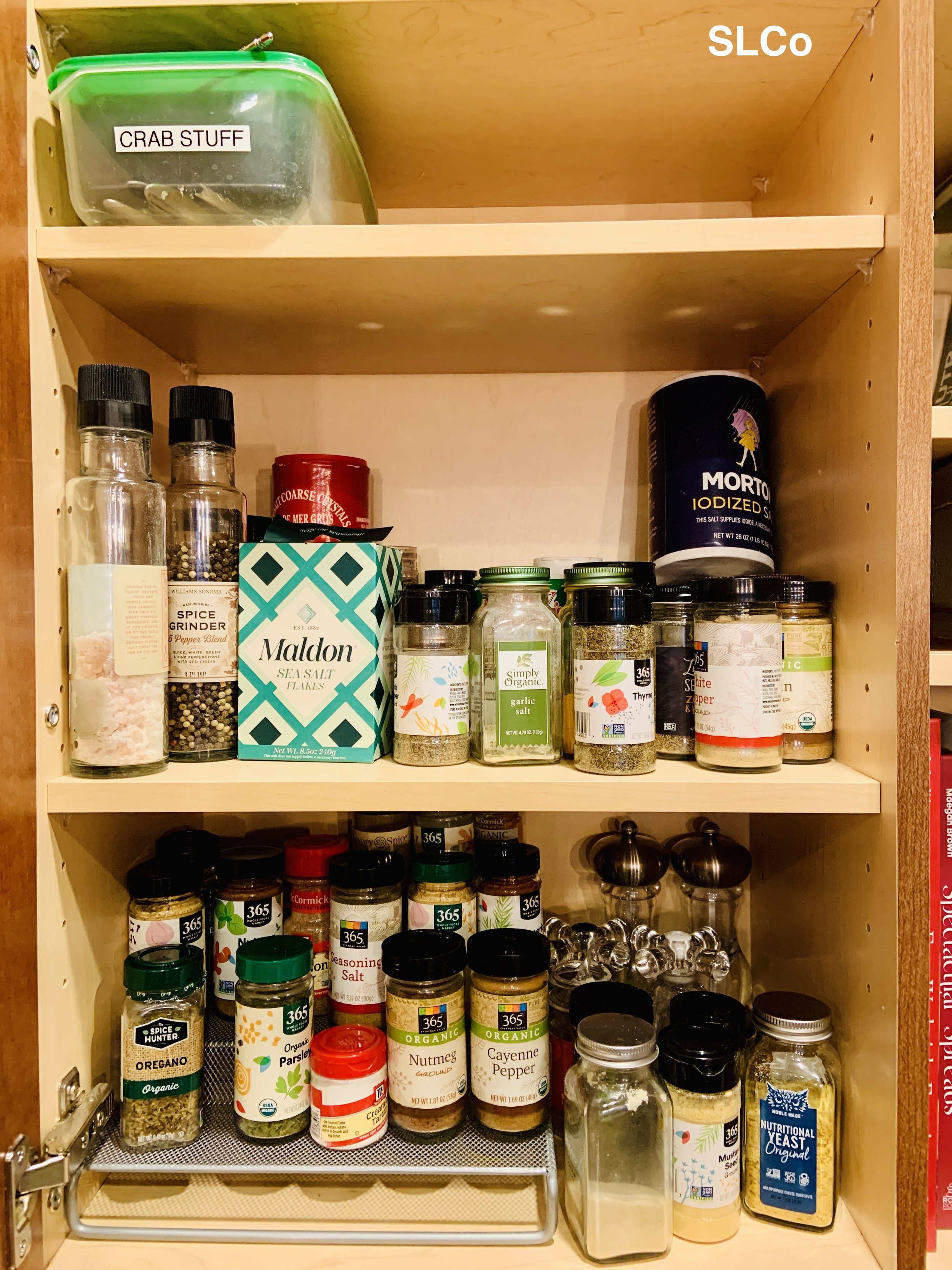 Before photo of thin 3 shelf pantry cabinet overflowing with spices