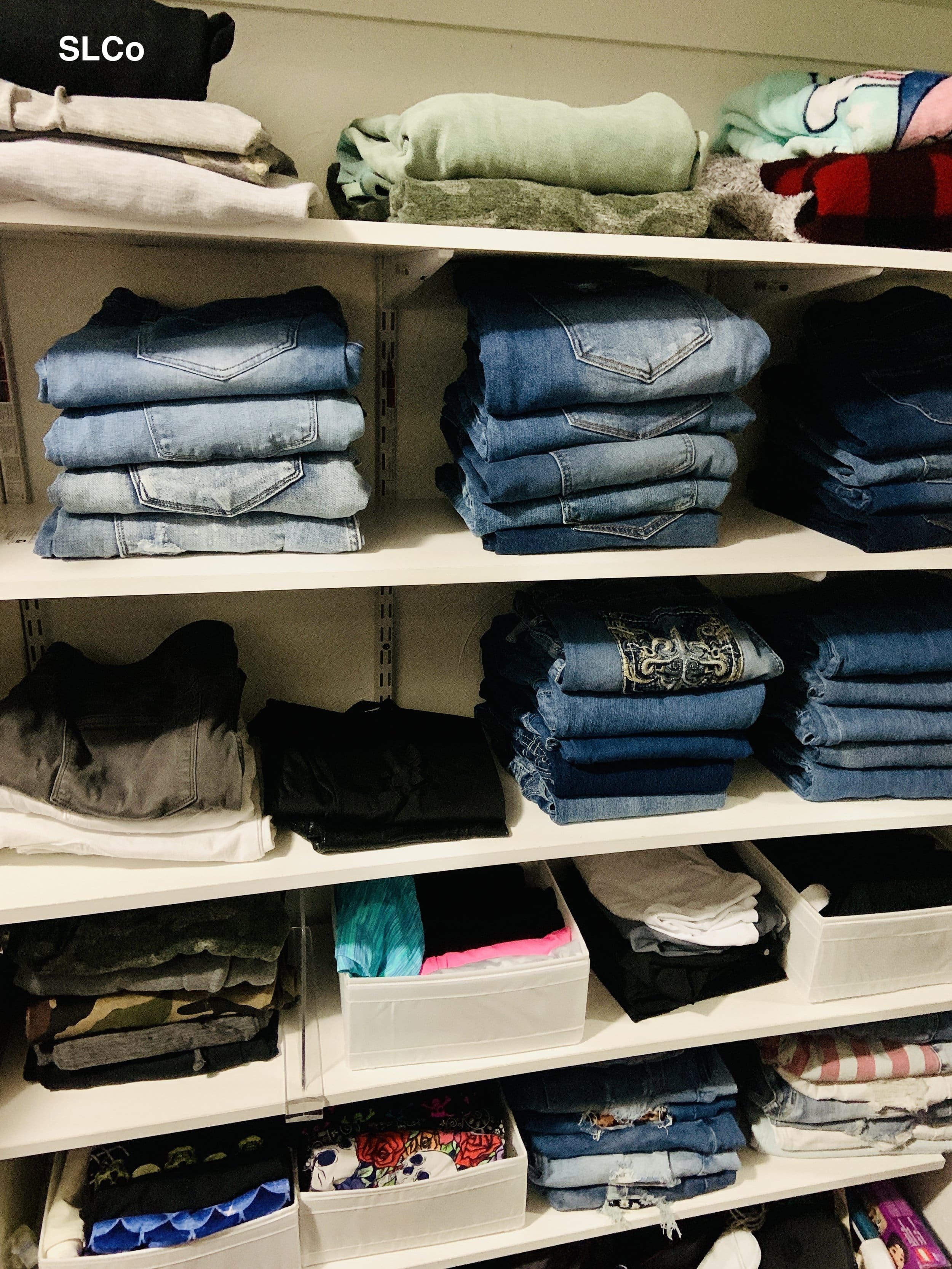 Closer image of shelves with folded jeans and items
