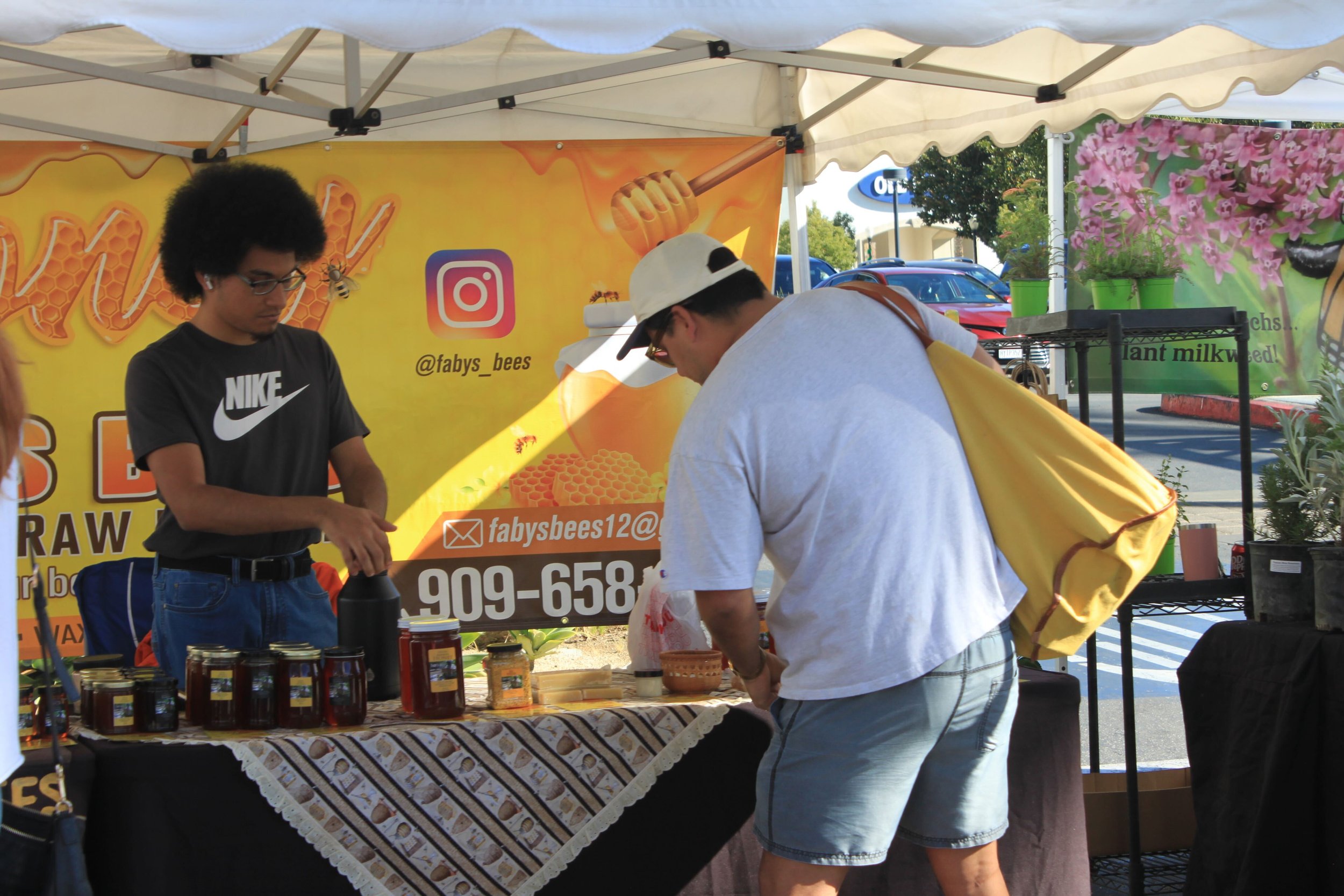  A customer engages in a sweet conversation with the honey vendor, discovering the golden treasures and stories behind each jar at the bustling market. Photo by Jess Rodrigo 