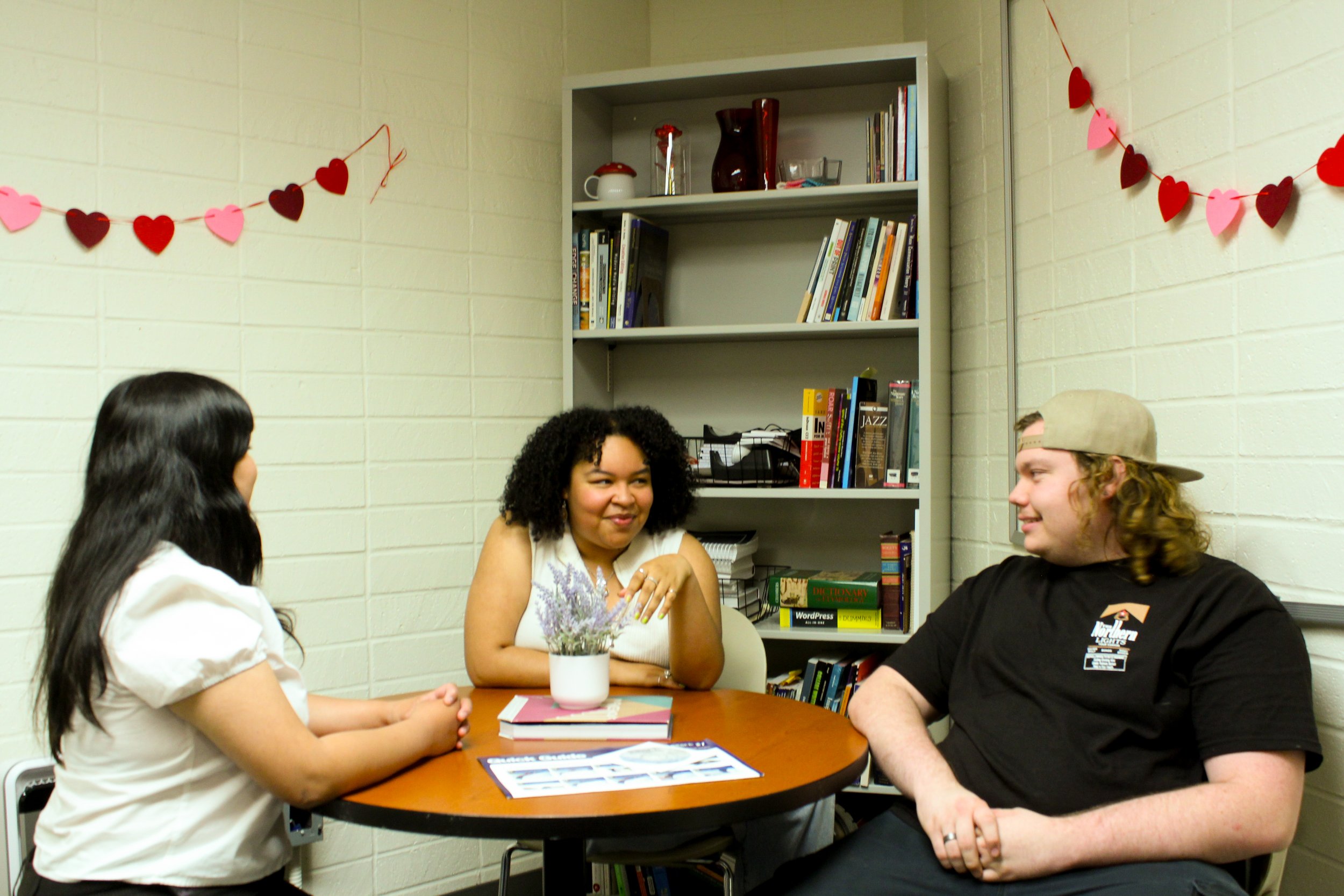 Bri, Nya Hardaway, and Nate Gosney having a conversation in the office.